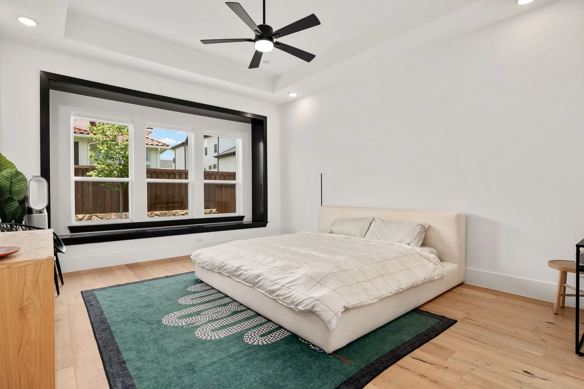 Recessed tray ceiling with a modern black ceiling fan featuring integrated lighting