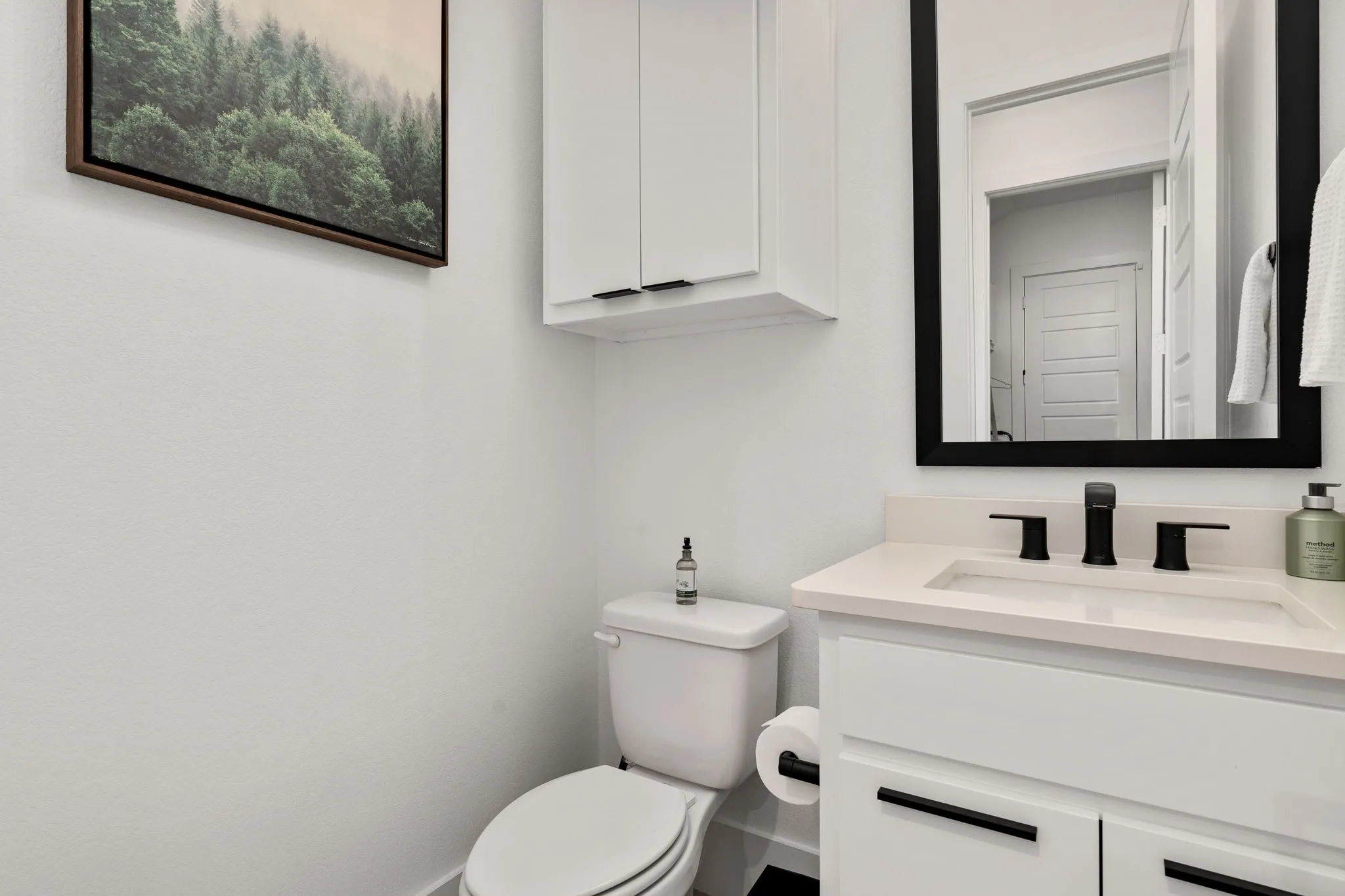 Bathroom vanity with a rectangular undermount sink, light-toned countertop, and matte black hardware