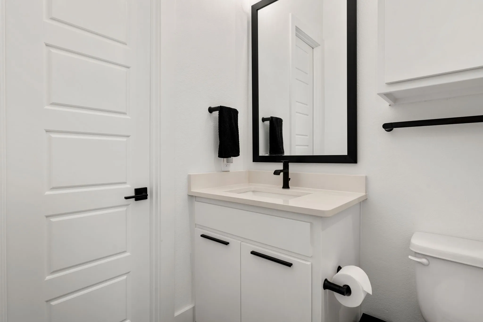 Vanity featuring a stone countertop, an undermount sink, and a matte black faucet