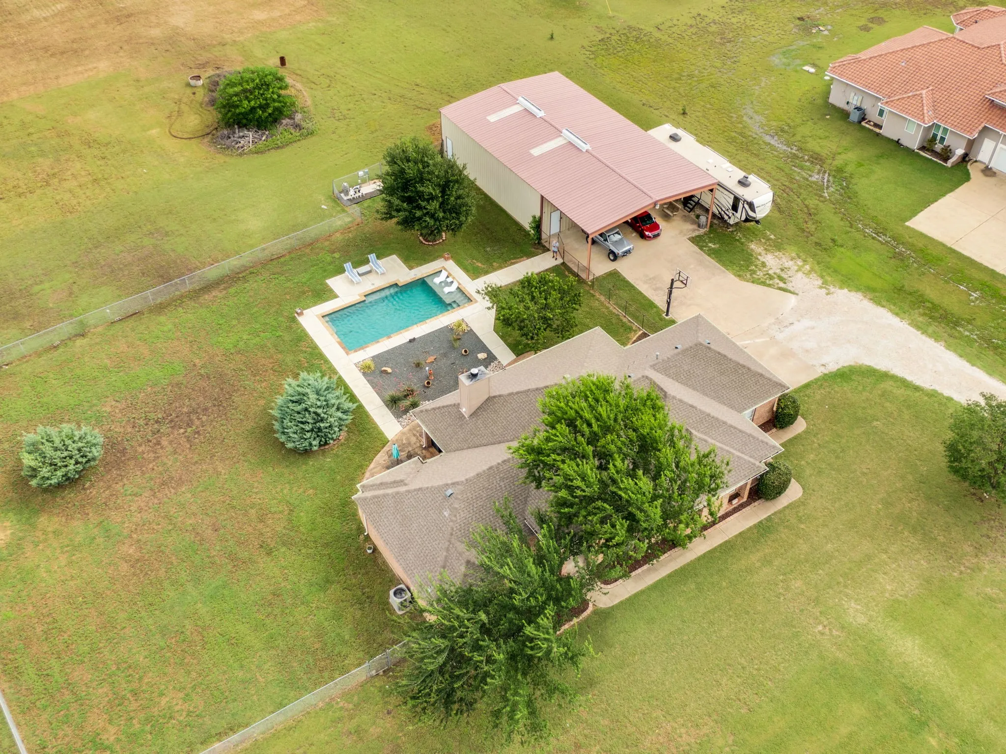 Aerial property view featuring a rectangular swimming pool with surrounding patio space