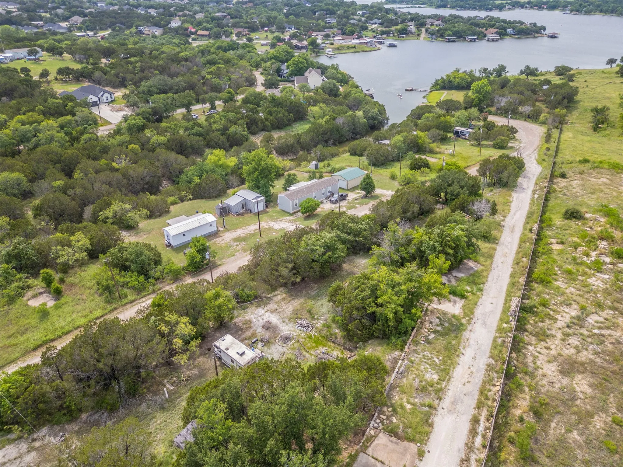 Expansive property featuring a waterfront setting with a lake, established trees, and a private dock