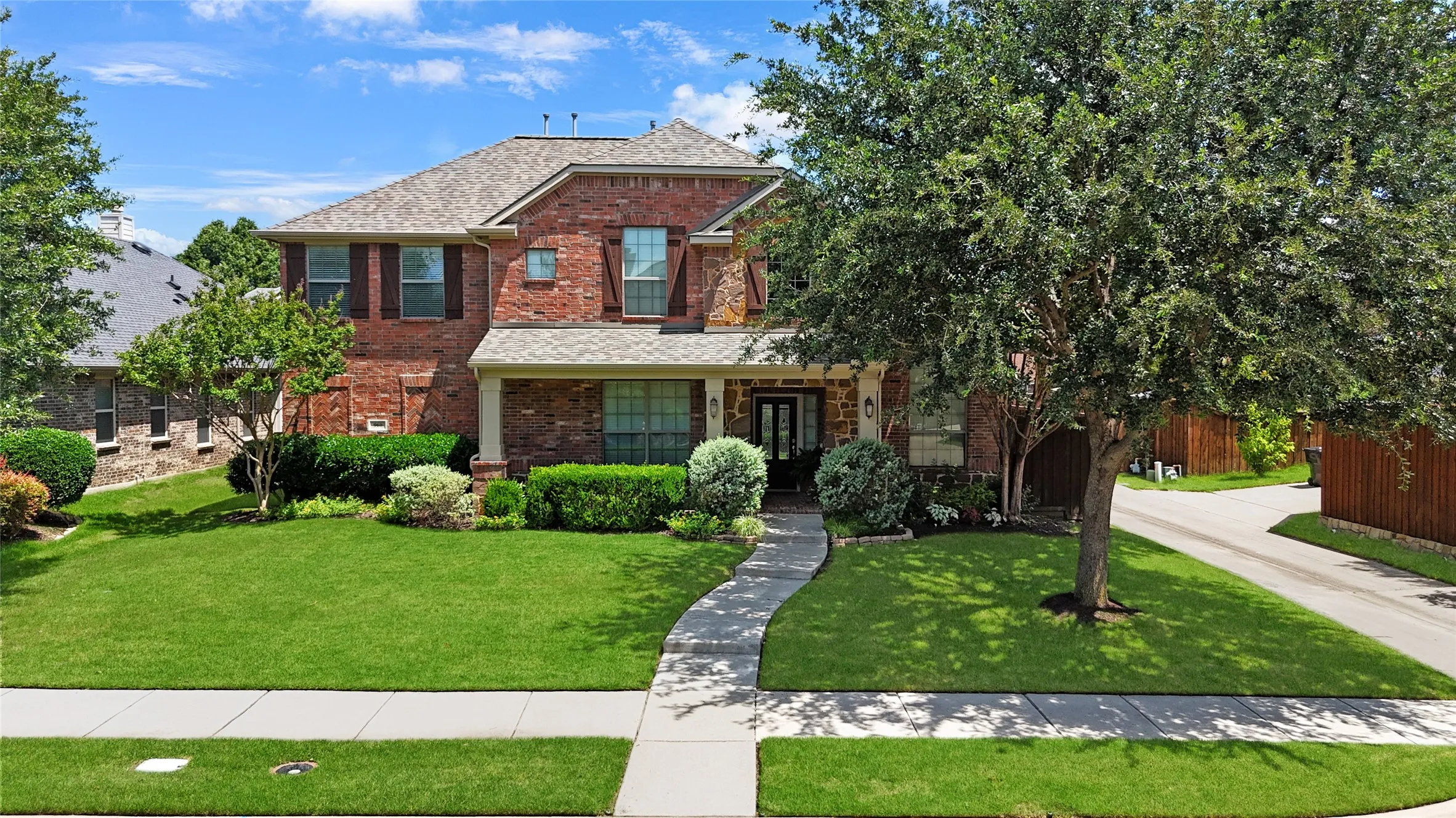 Traditional brick-faced residence featuring a gabled roofline and shutters