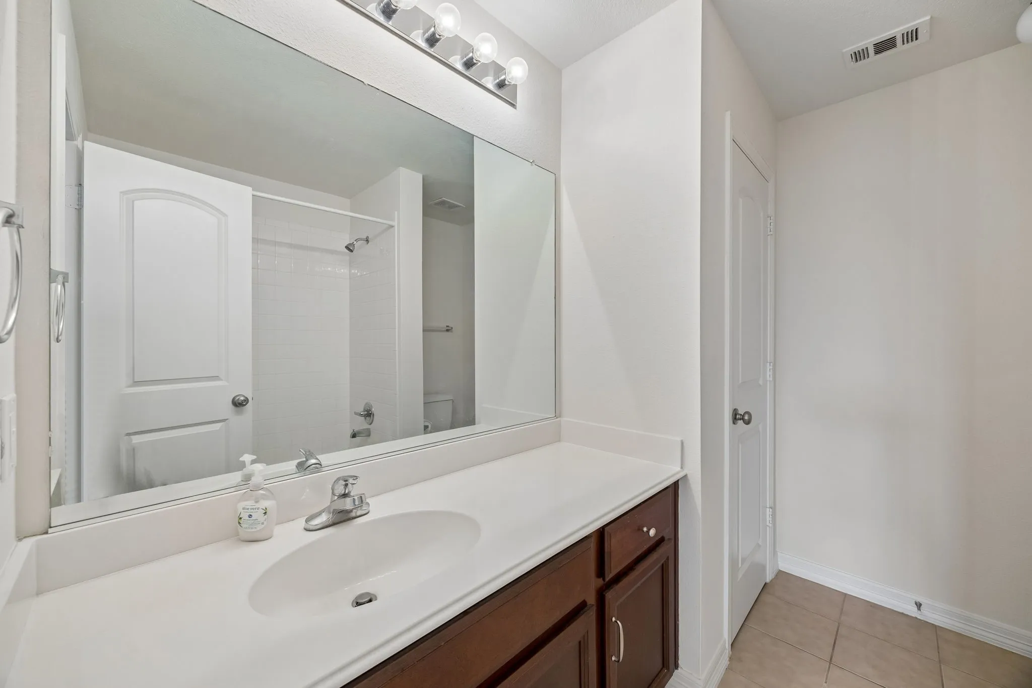 Vanity with an integrated sink, polished chrome faucet, and wood-finish cabinetry