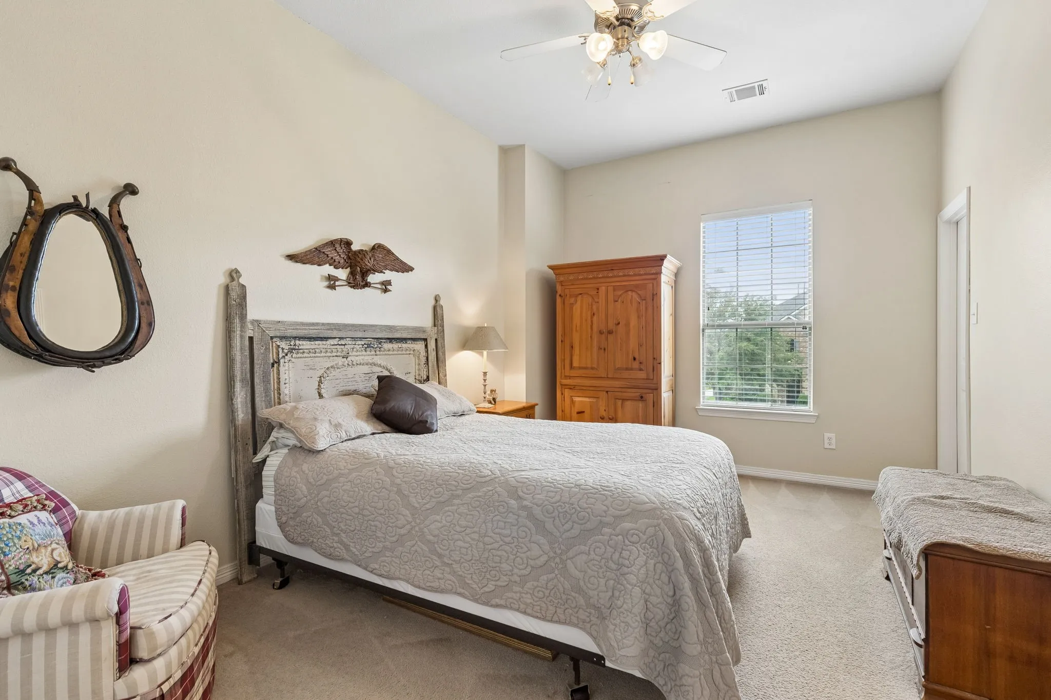 Vaulted ceiling, carpet flooring, ceiling fan, single window, and a paneled door