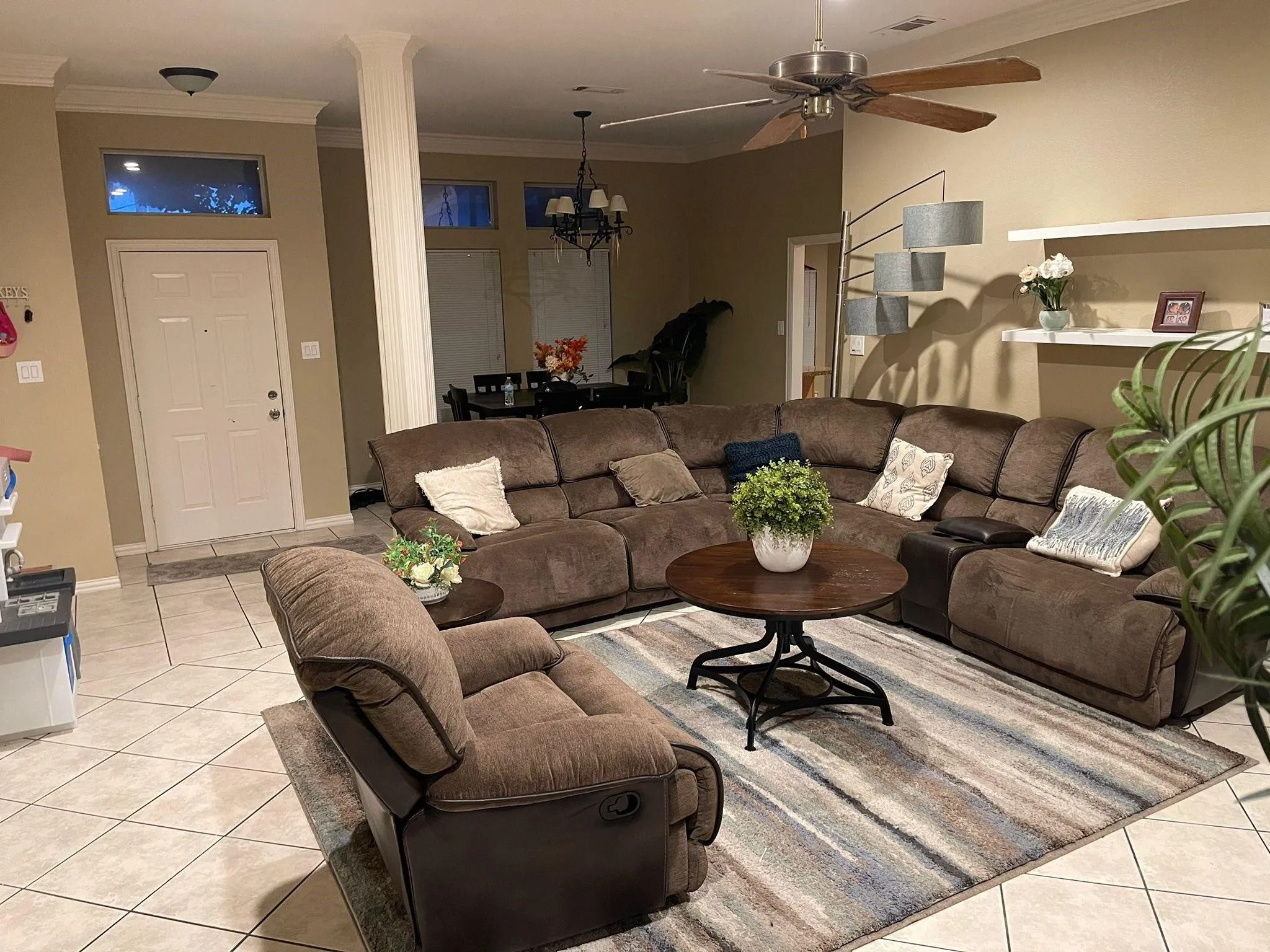 Open-concept living area with neutral wall tones and tile flooring