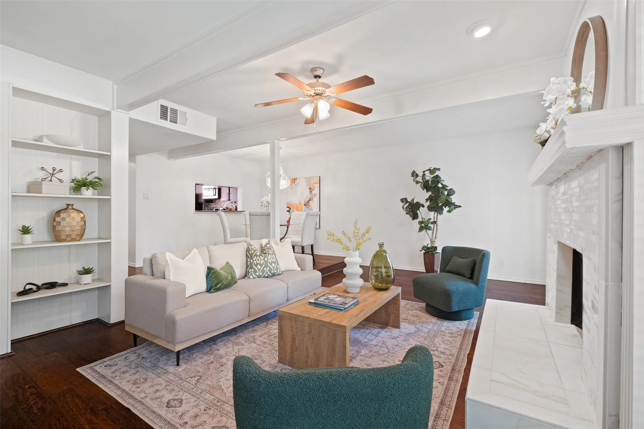 Living room with built-in shelving, open sightlines to the dining area and kitchen, and a tile-surround fireplace — an ideal layout for both entertaining and everyday living.
