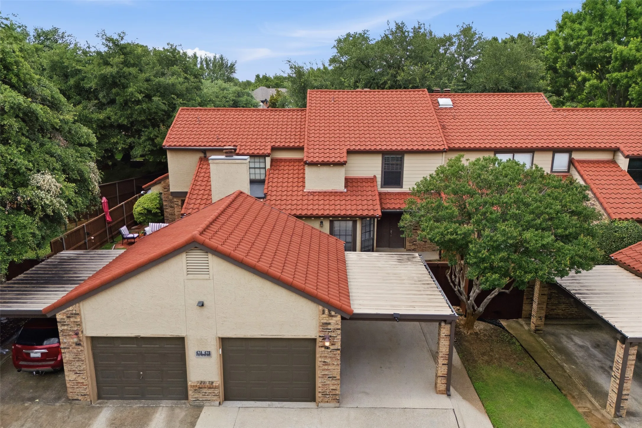 Daytime aerial view highlighting the one-car detached garage, and covered parking for an additional vehicle.