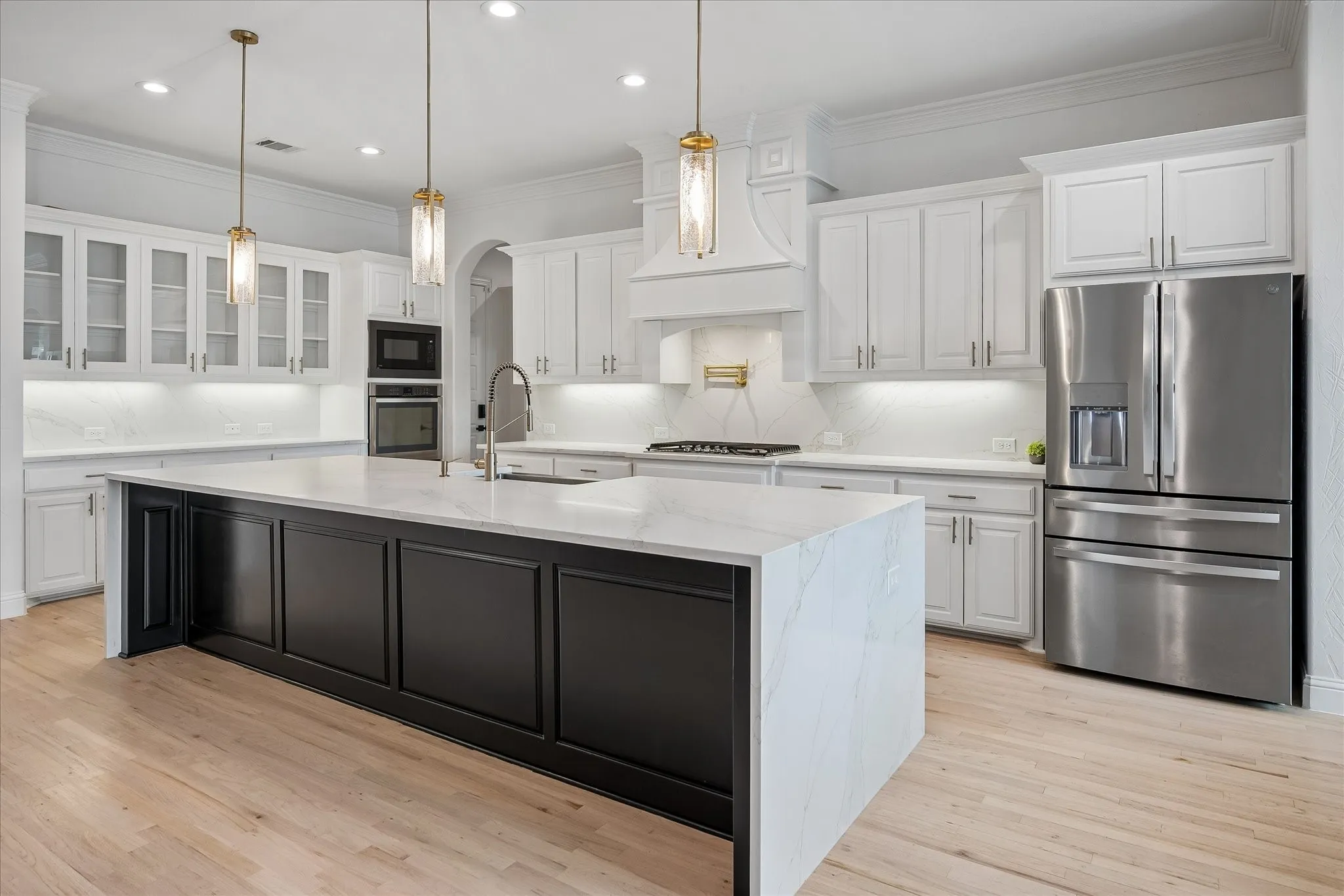 Beautiful Pendant Lights above Island, Pot Filler at cooktop and glass doors in some cabinets