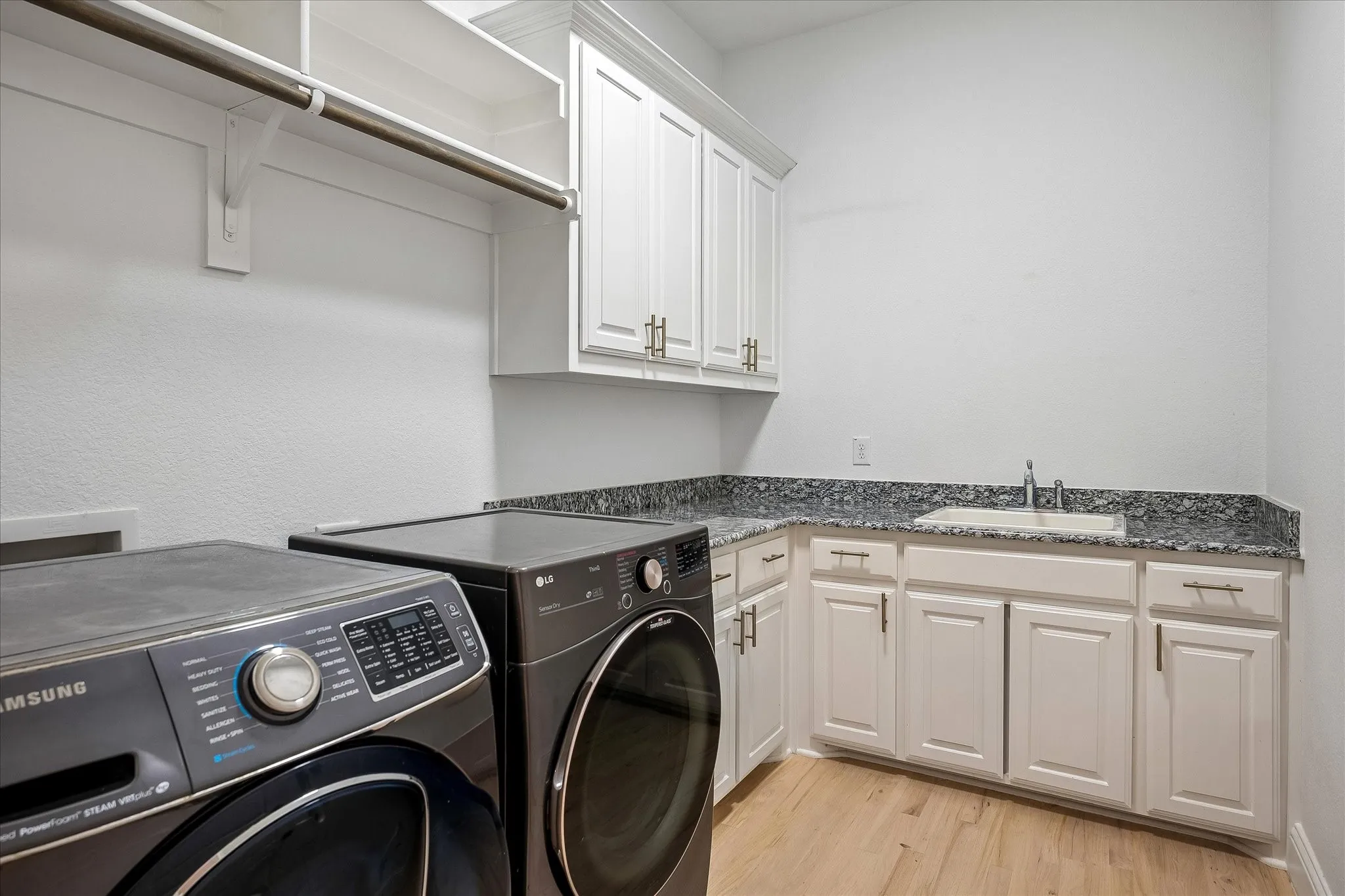 Utility Room has sink, storage and hanging bar