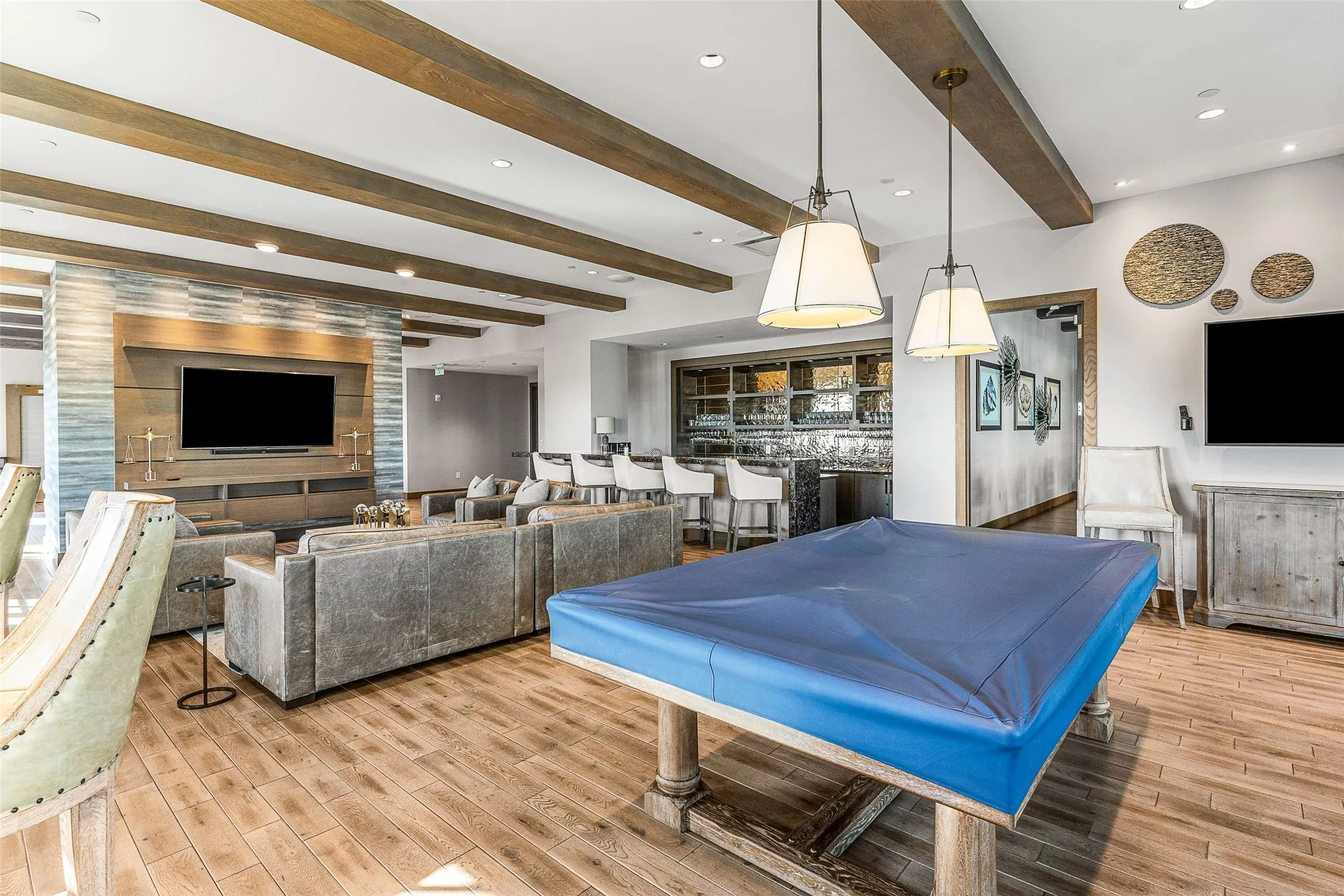 Community Open-concept recreational space featuring wood-finish flooring and exposed ceiling beams