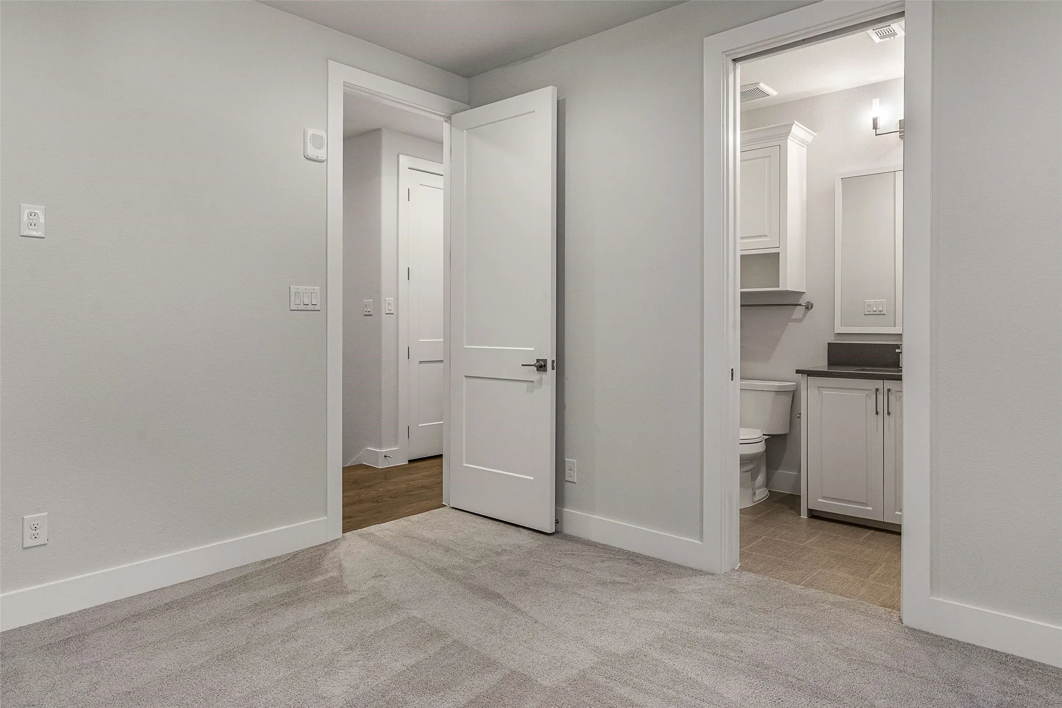 Plush gray carpeting with white baseboards and neutral wall tones
