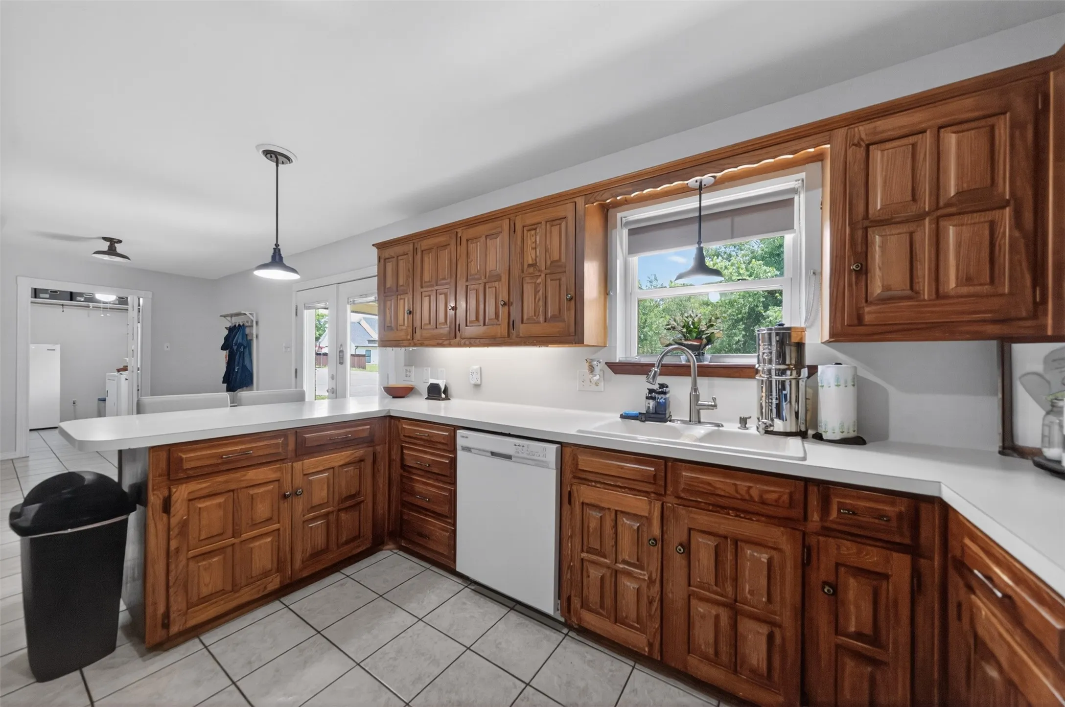 Kitchen featuring wood cabinetry, light countertops, and tile flooring