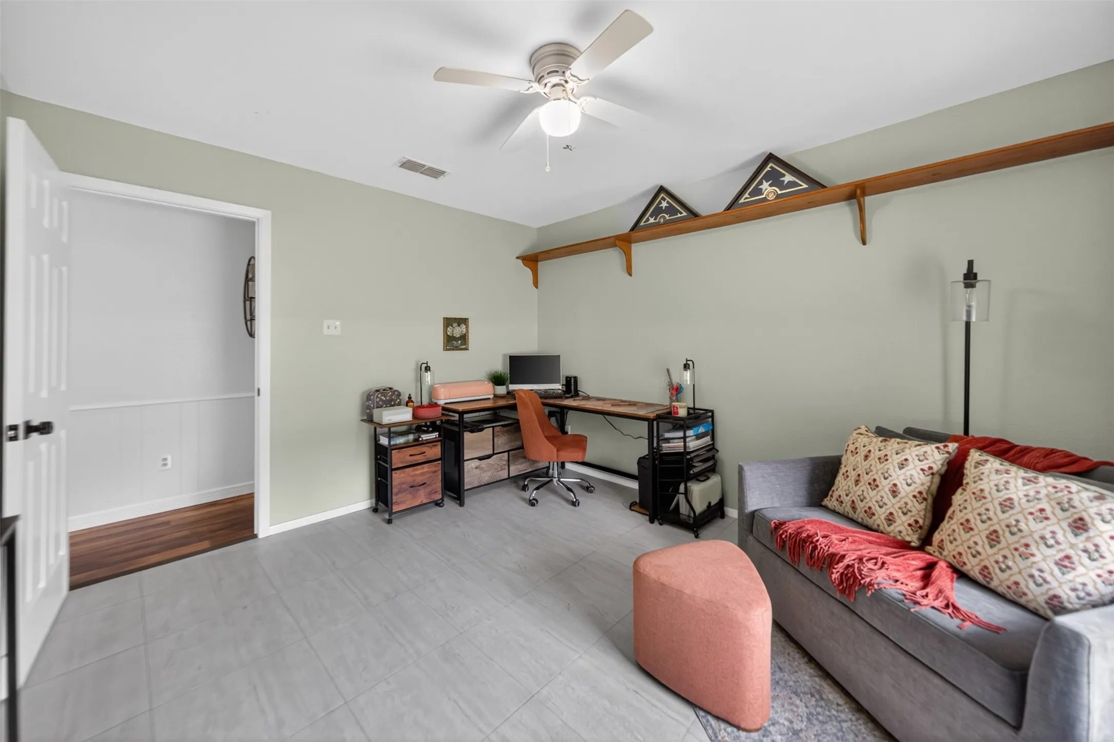 Spacious room featuring light-toned walls, tile flooring, and an overhead ceiling fan