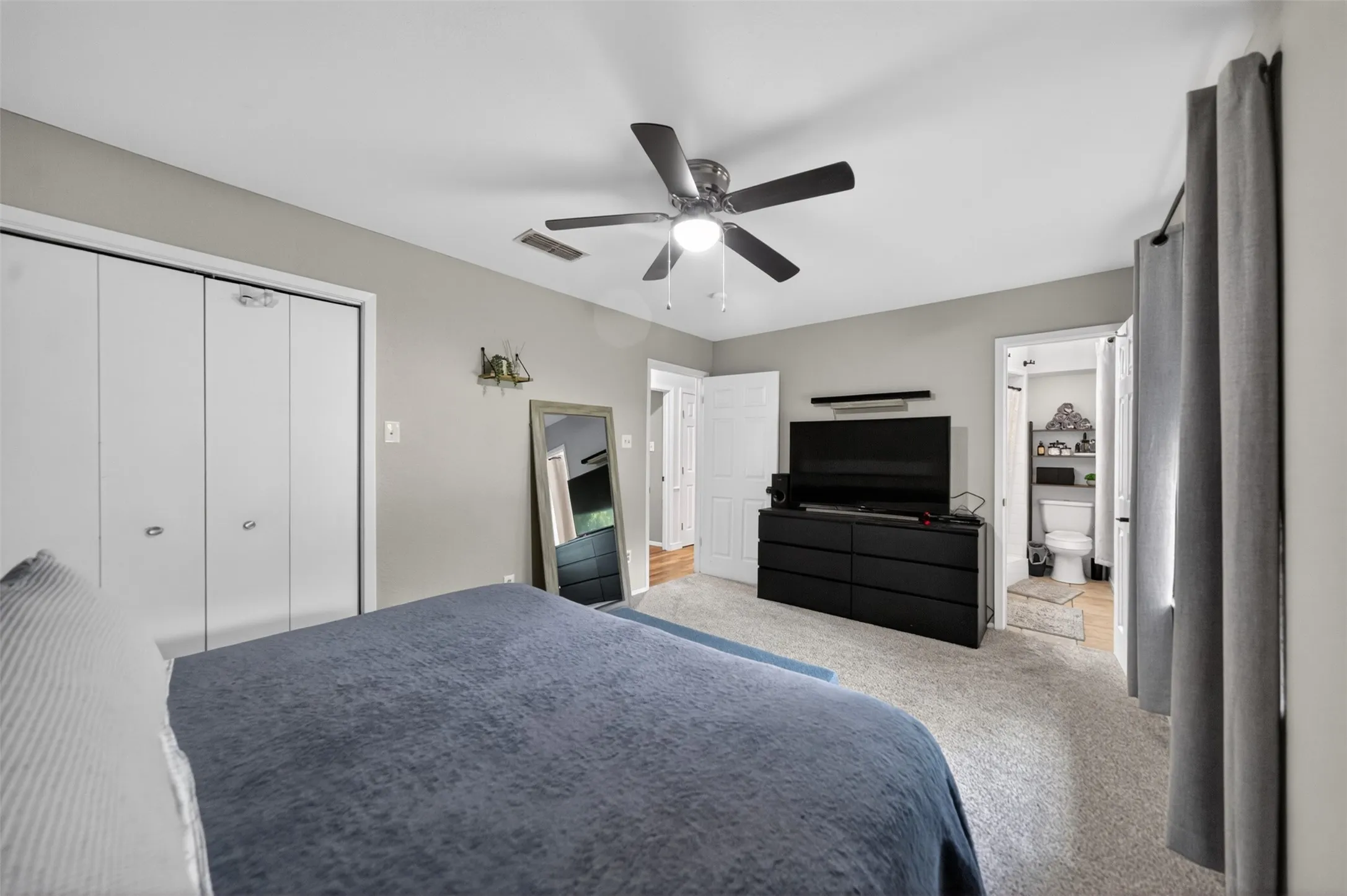 Carpeted room with light gray walls and a ceiling fan
