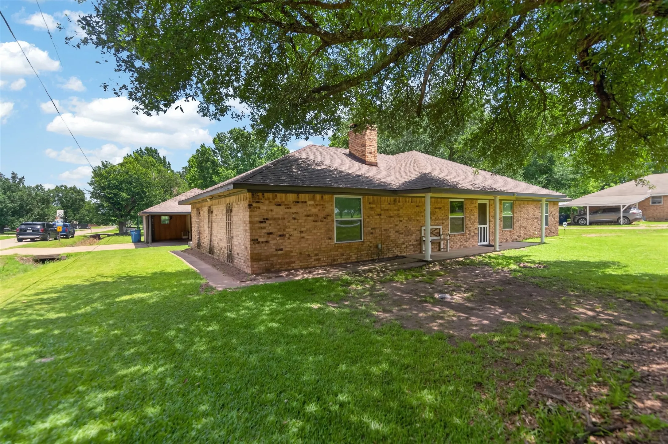 Brick exterior with a covered patio and a gabled roof