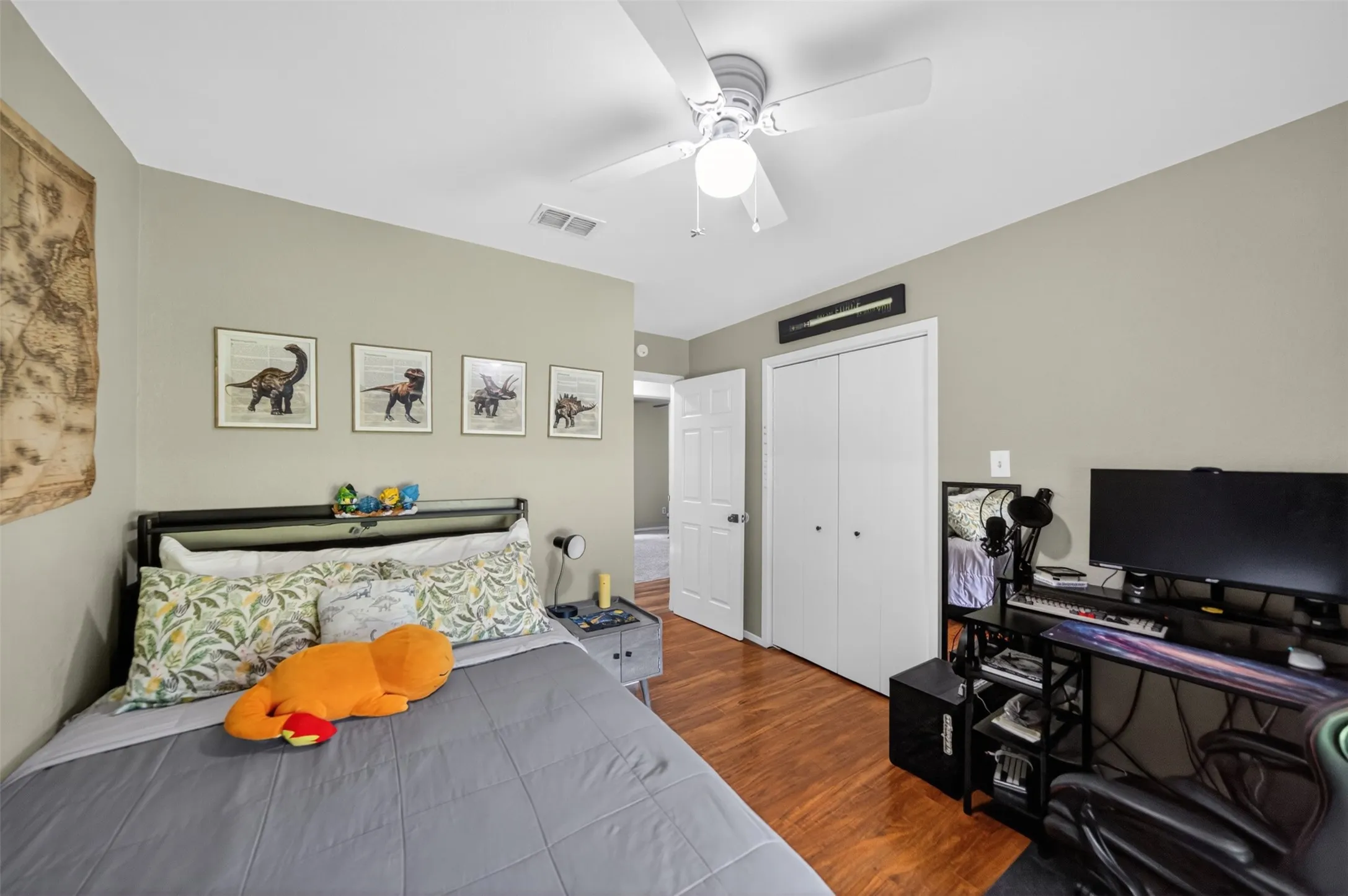 Interior room featuring wood-finish flooring, a ceiling fan with integrated lighting, and neutral wall tones