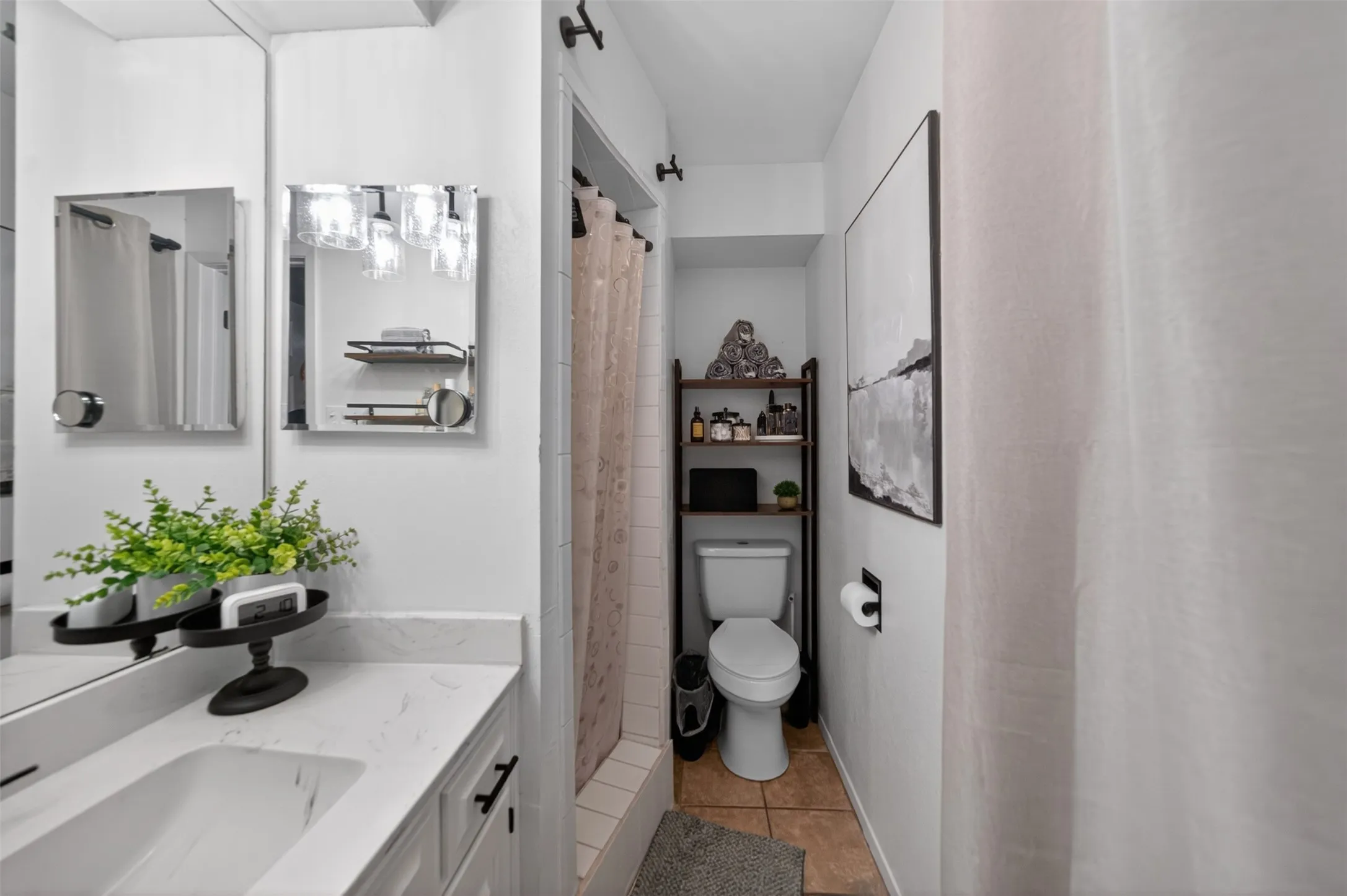 Bathroom featuring a white vanity with an integrated sink, polished chrome fixtures, and a glass-enclosed shower with subway tile surround