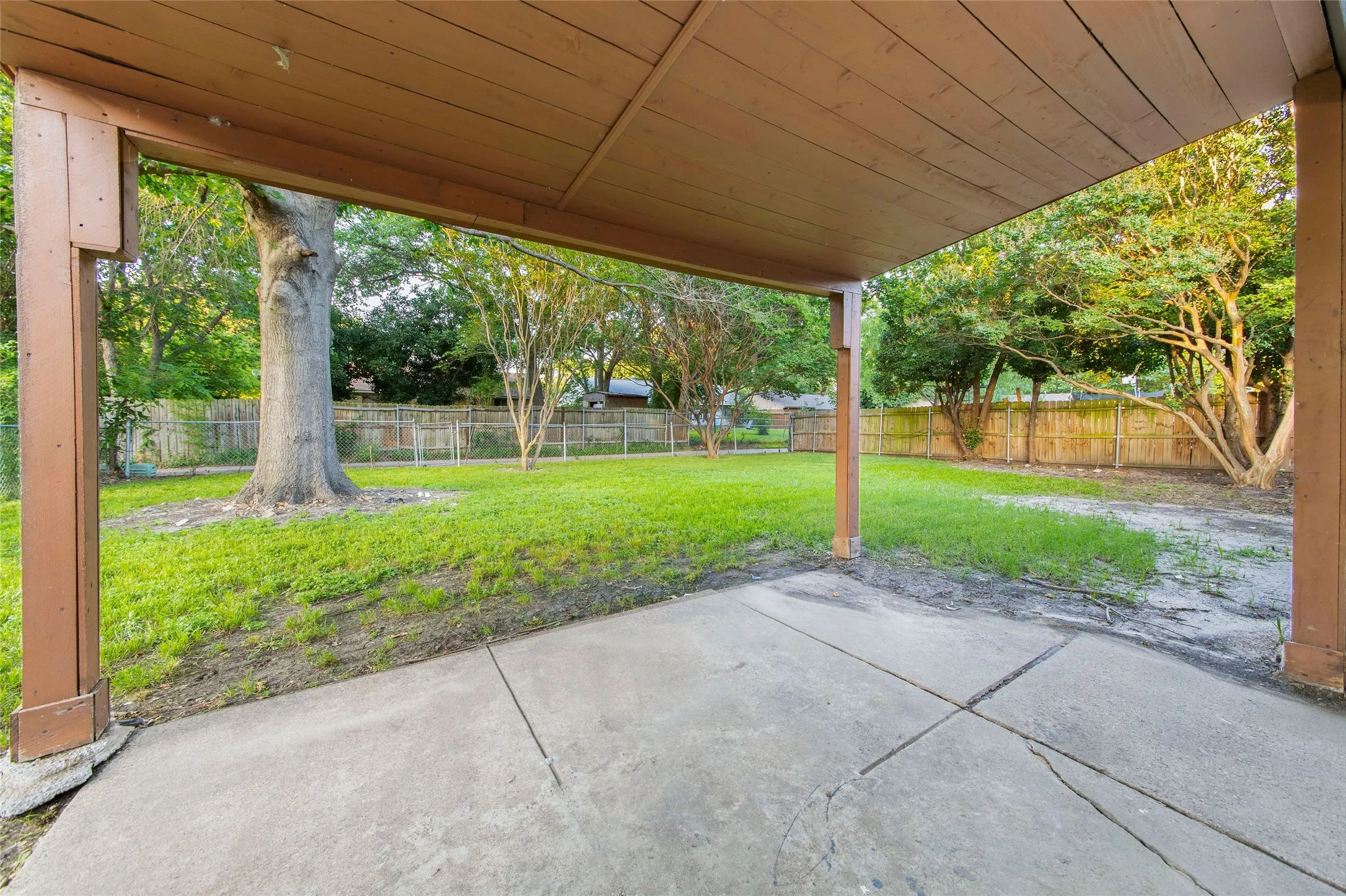 Covered patio area opening to a green lawn
