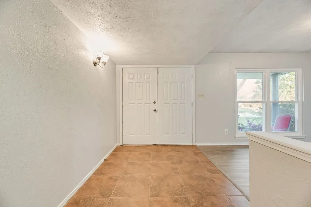 Entryway featuring double panel doors and warm-toned tile flooring