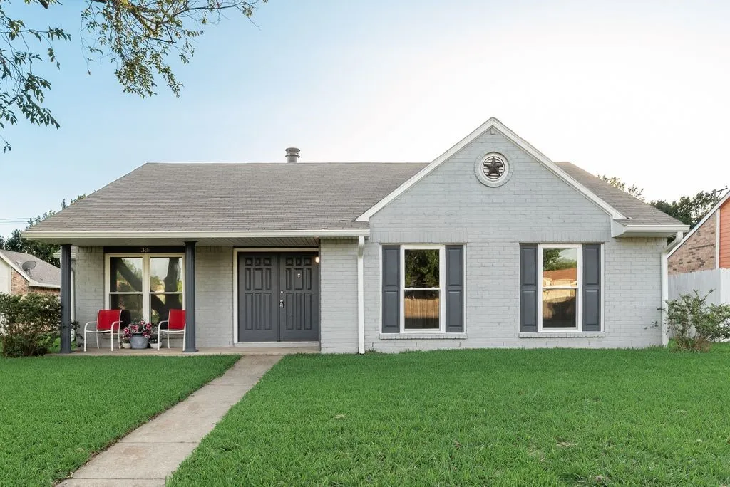 Single-story residence featuring a gray brick facade and a prominent front gable with a decorative medallion