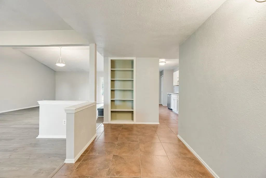 Entryway featuring tile flooring, built-in shelving, and light-toned walls