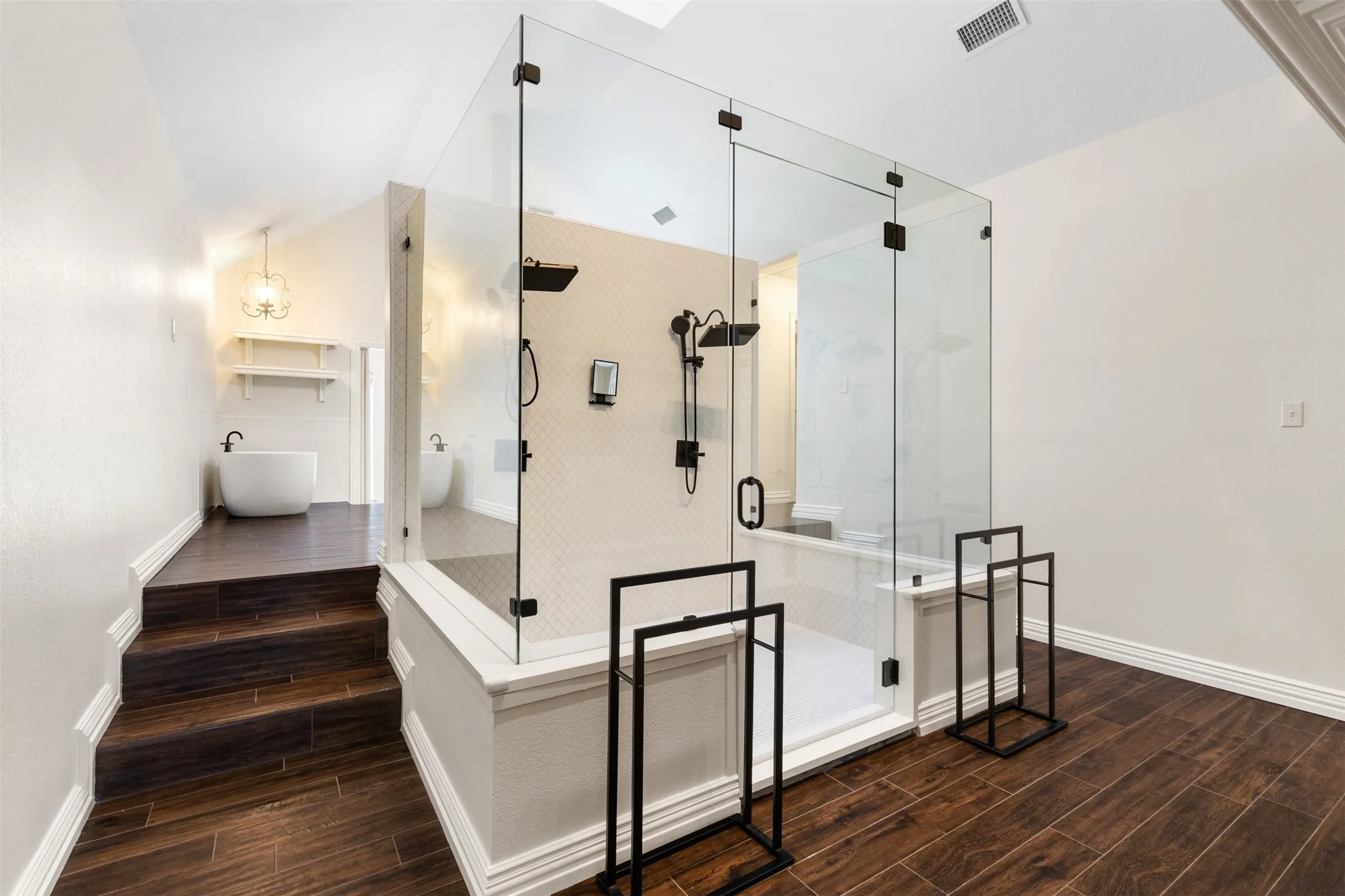 Primary en-suite bathroom feels like a spa with this stunning oversized double shower & dual-side fireplace.