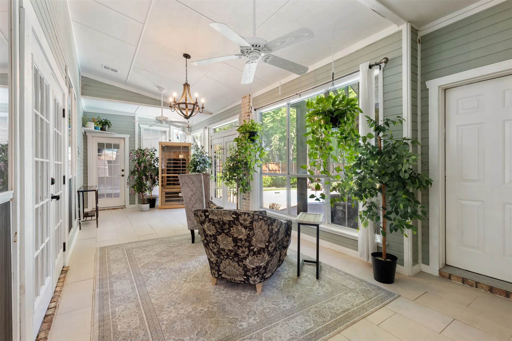 Enclosed Sunroom with doors to primary bed, living, garage & backyard.