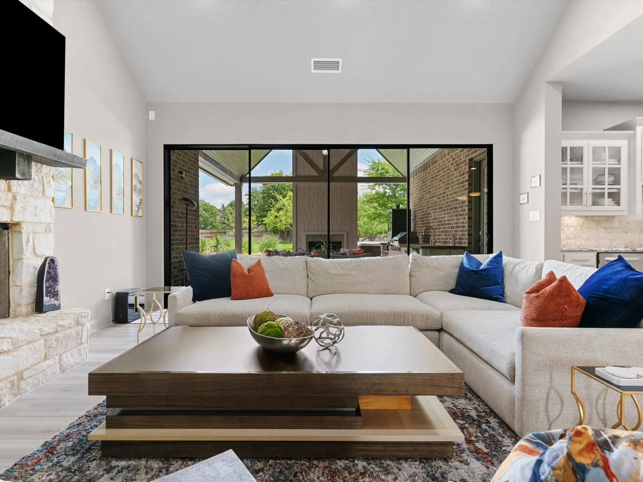 Large living room featuring luxury vinyl plank flooring, abundant natural light, and a dramatic oversized sliding glass door.