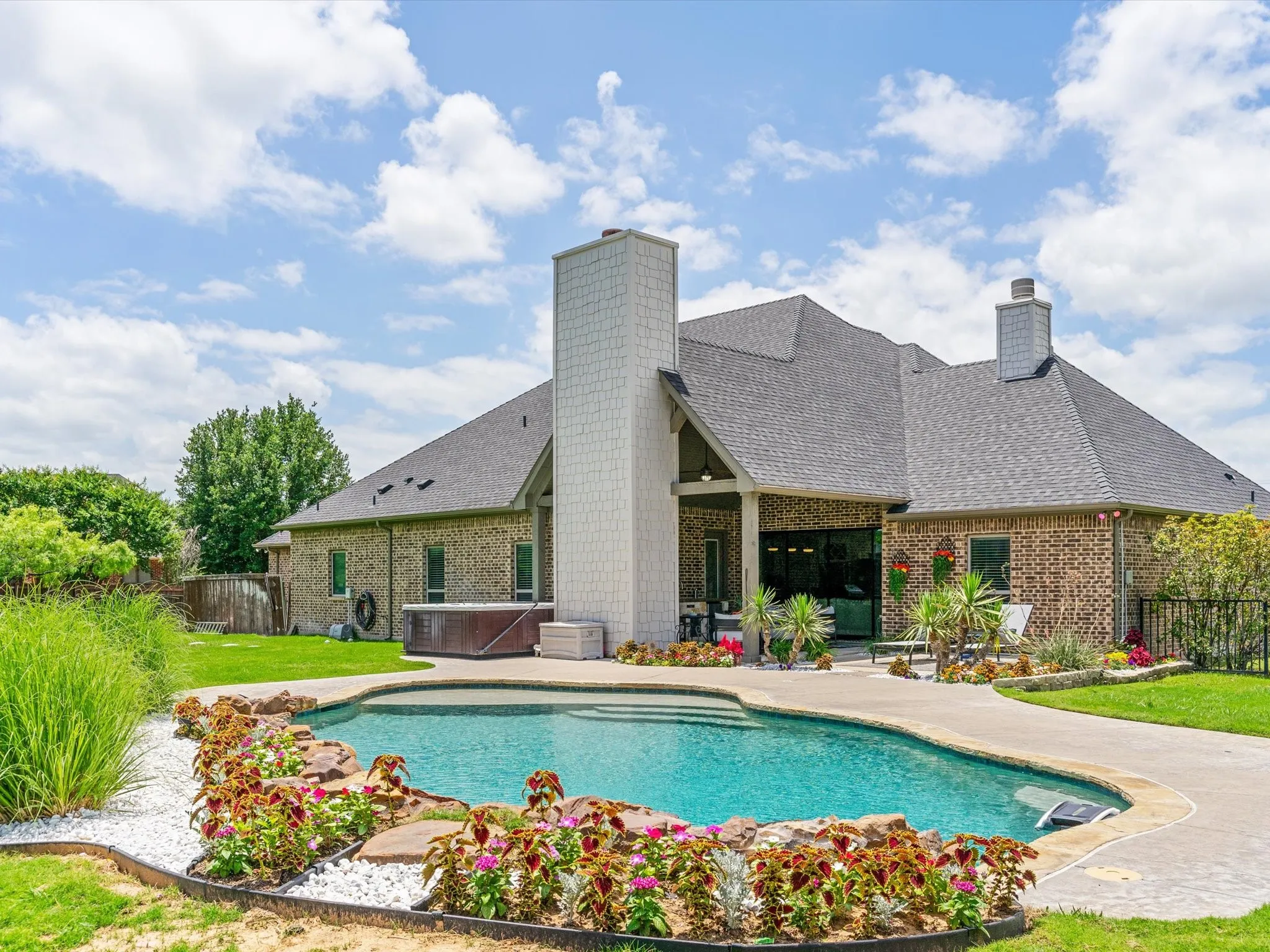 Resort-style saltwater pool and spa surrounded by professional landscaping and outdoor living spaces.