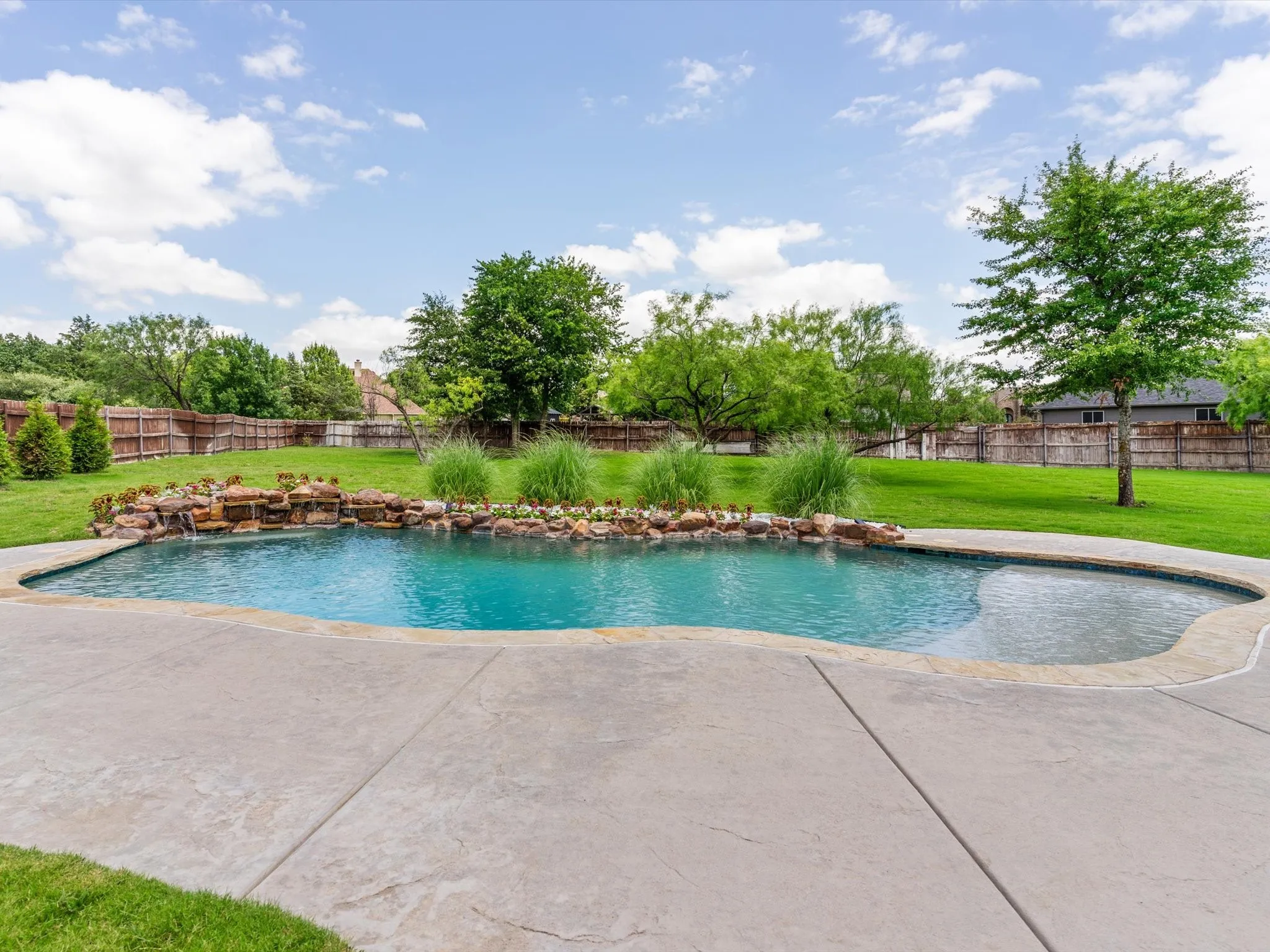 Resort-style saltwater pool and spa surrounded by professional landscaping and outdoor living spaces.