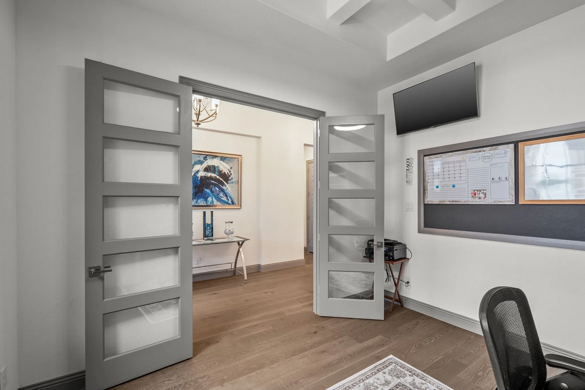 Hardwood-finish flooring throughout, complemented by a tray ceiling with recessed lighting