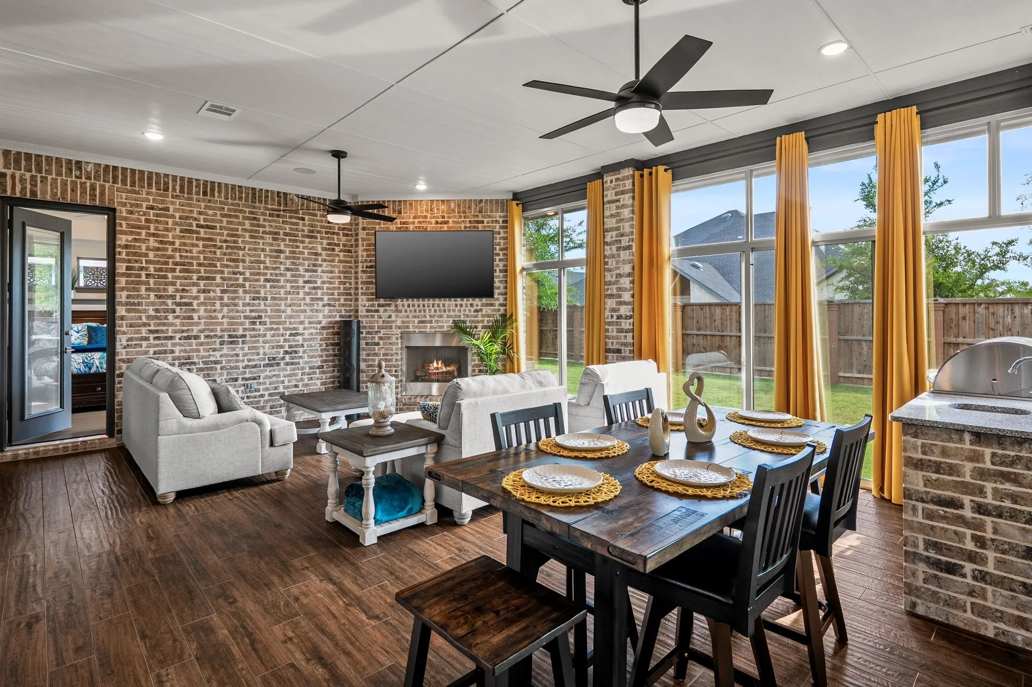 Expansive outdoor living area featuring brick accent walls and wood-finish flooring