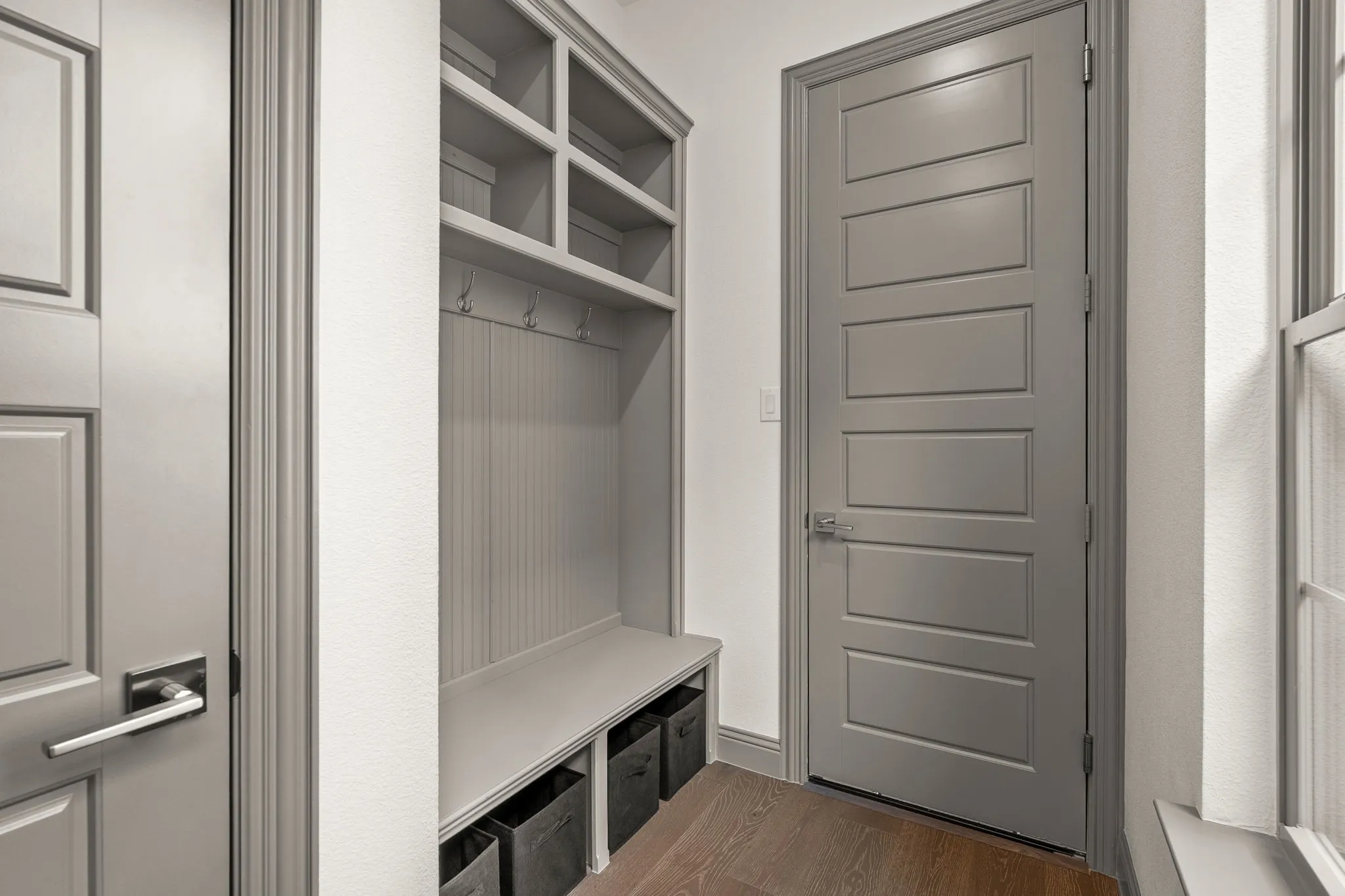 Mudroom built-in storage with upper cubbies, coat hooks, and bench seating