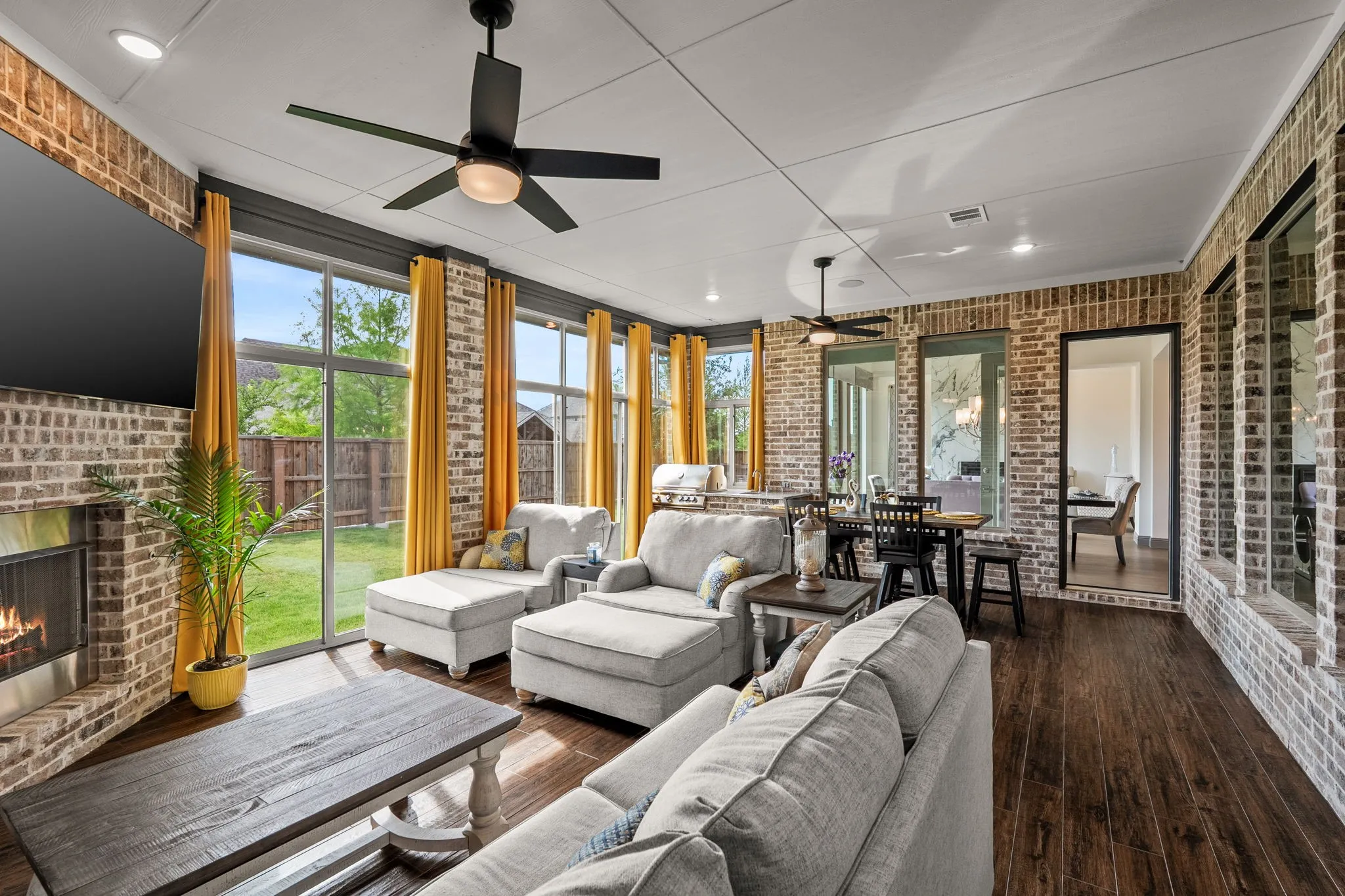 Sliding glass enclosed living space featuring HVAC, extensive brickwork, wood-finish flooring, a built-in fireplace, and expansive windows
