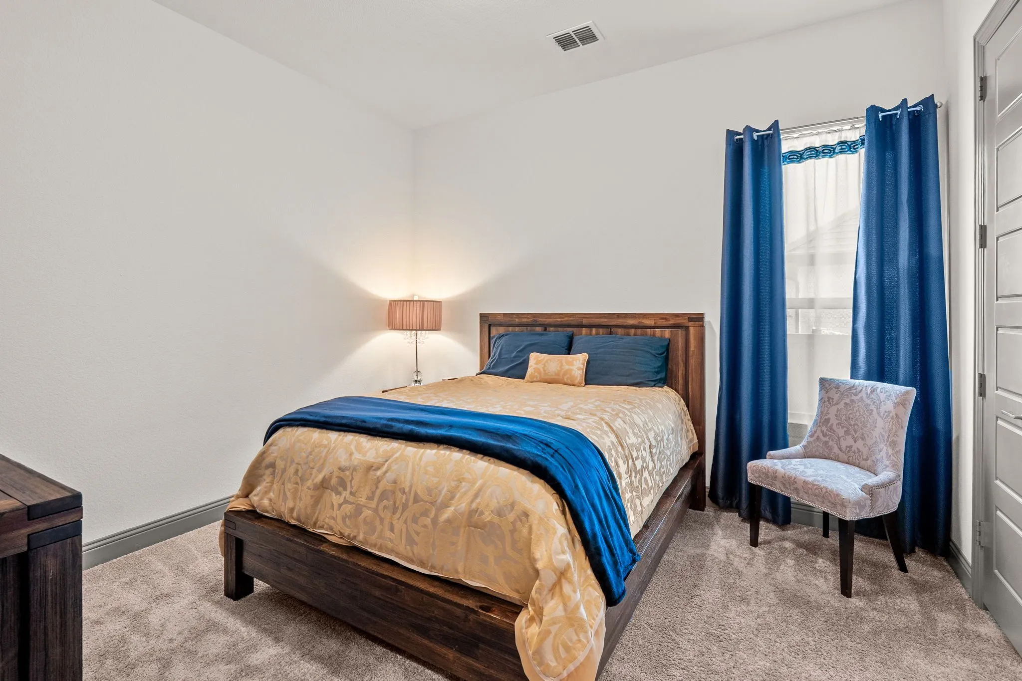 Spacious bedroom featuring light-colored carpeting and a window with grey trim