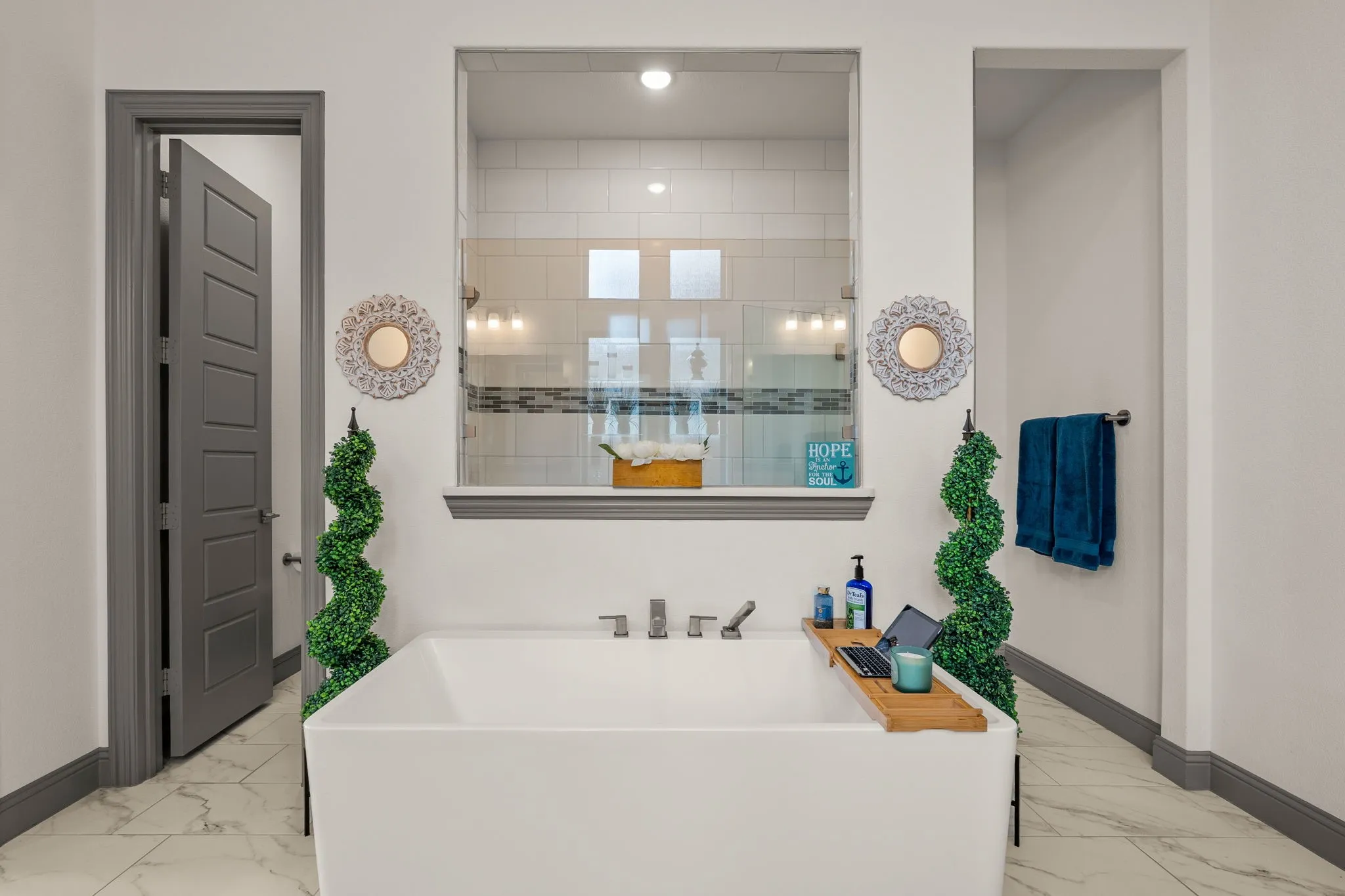 Freestanding soaking tub with contemporary fixtures, set against a backdrop of white walls and grey trim