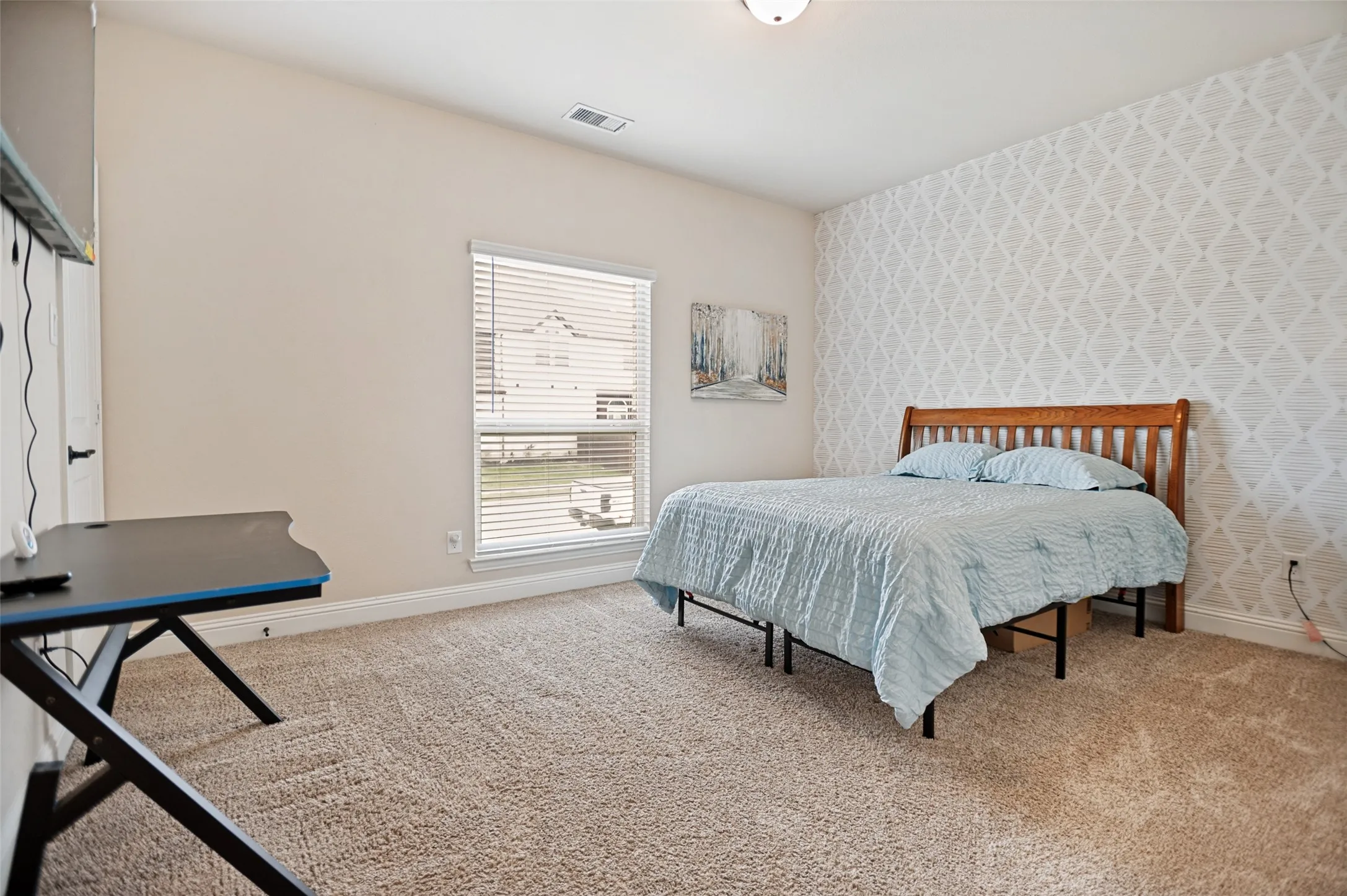 Carpeted room featuring a single window with blinds and a patterned accent wall