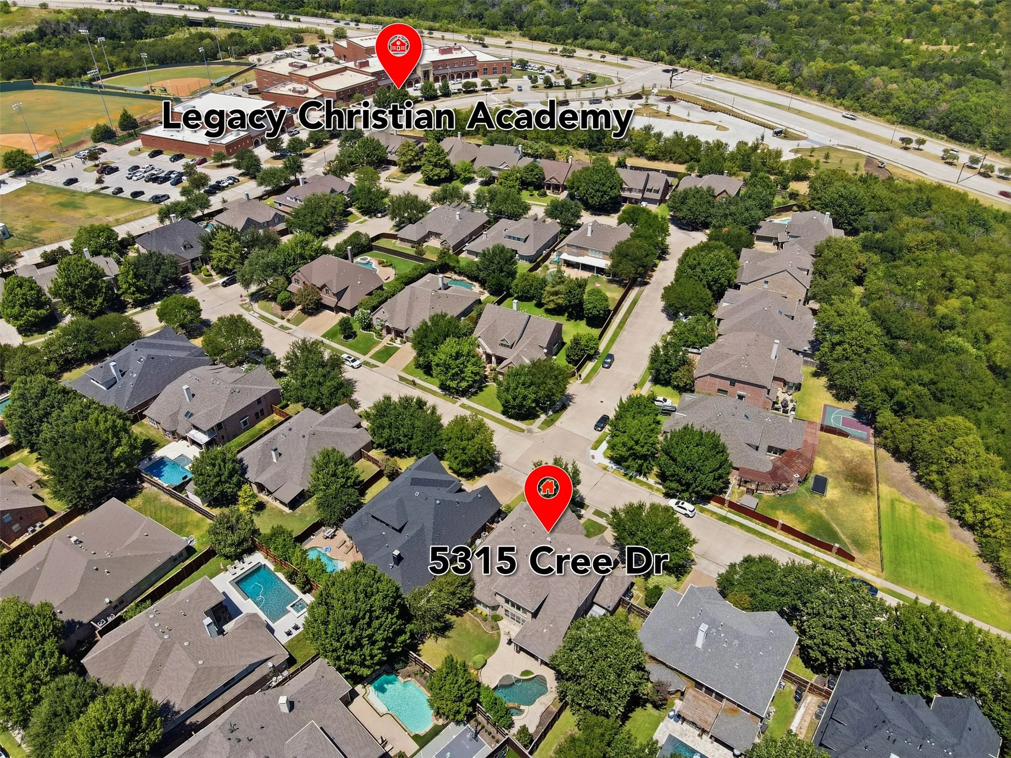 Aerial perspective of a residential neighborhood with mature trees and swimming pools