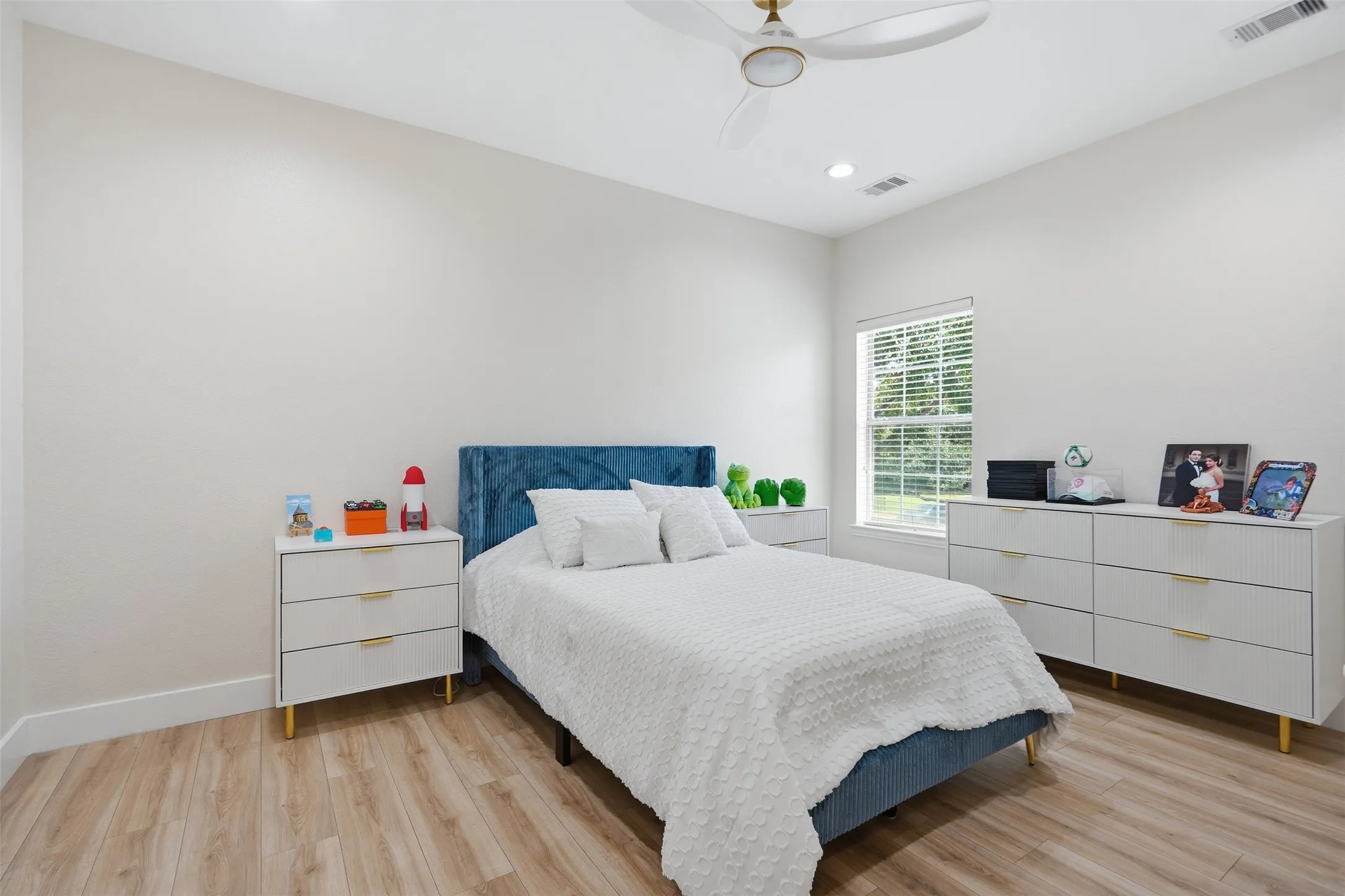 Wood-finish flooring, recessed lighting, ceiling fan, and window with blinds