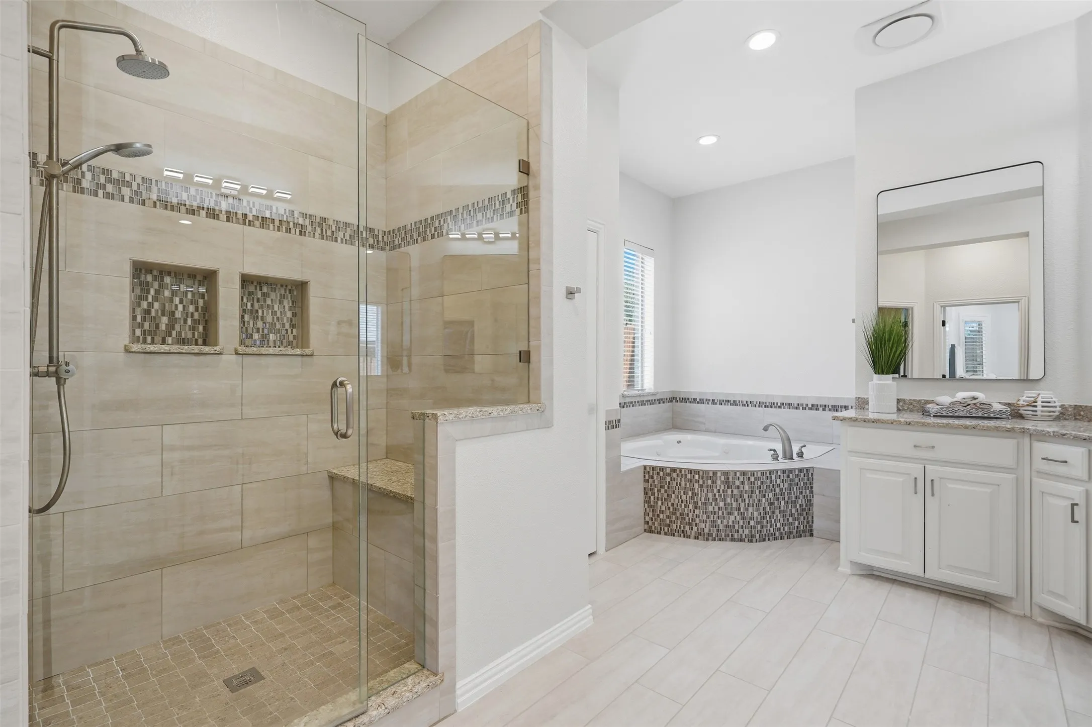 Glass-enclosed shower with a built-in bench and dual inset shelves