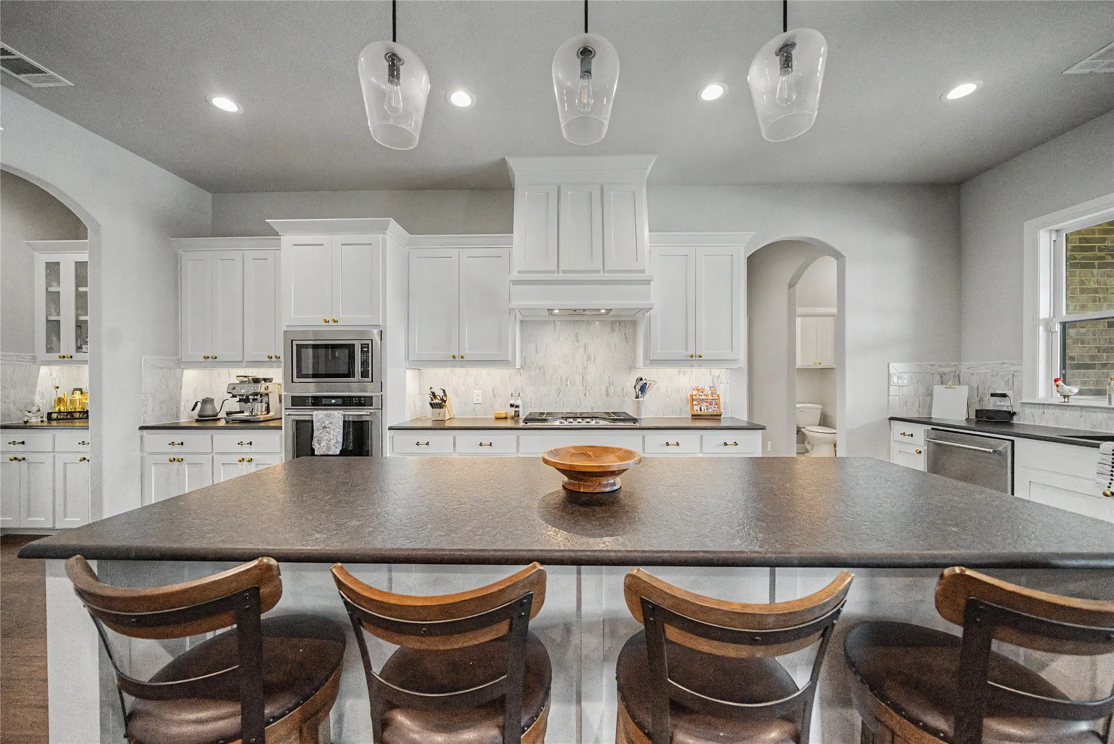 Expansive kitchen island with dark countertop