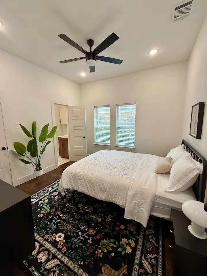 Bedroom featuring dark wood-finish flooring, two window openings with blinds, a ceiling fan, and recessed lighting