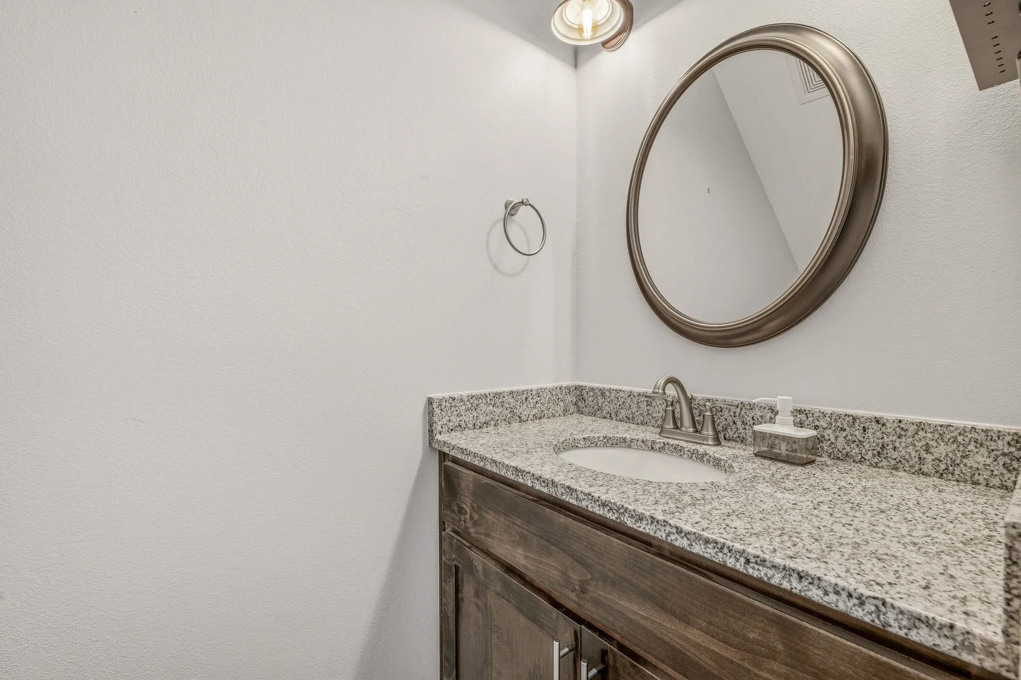 Vanity featuring a stone-finish countertop, undermount sink, and brushed nickel faucet