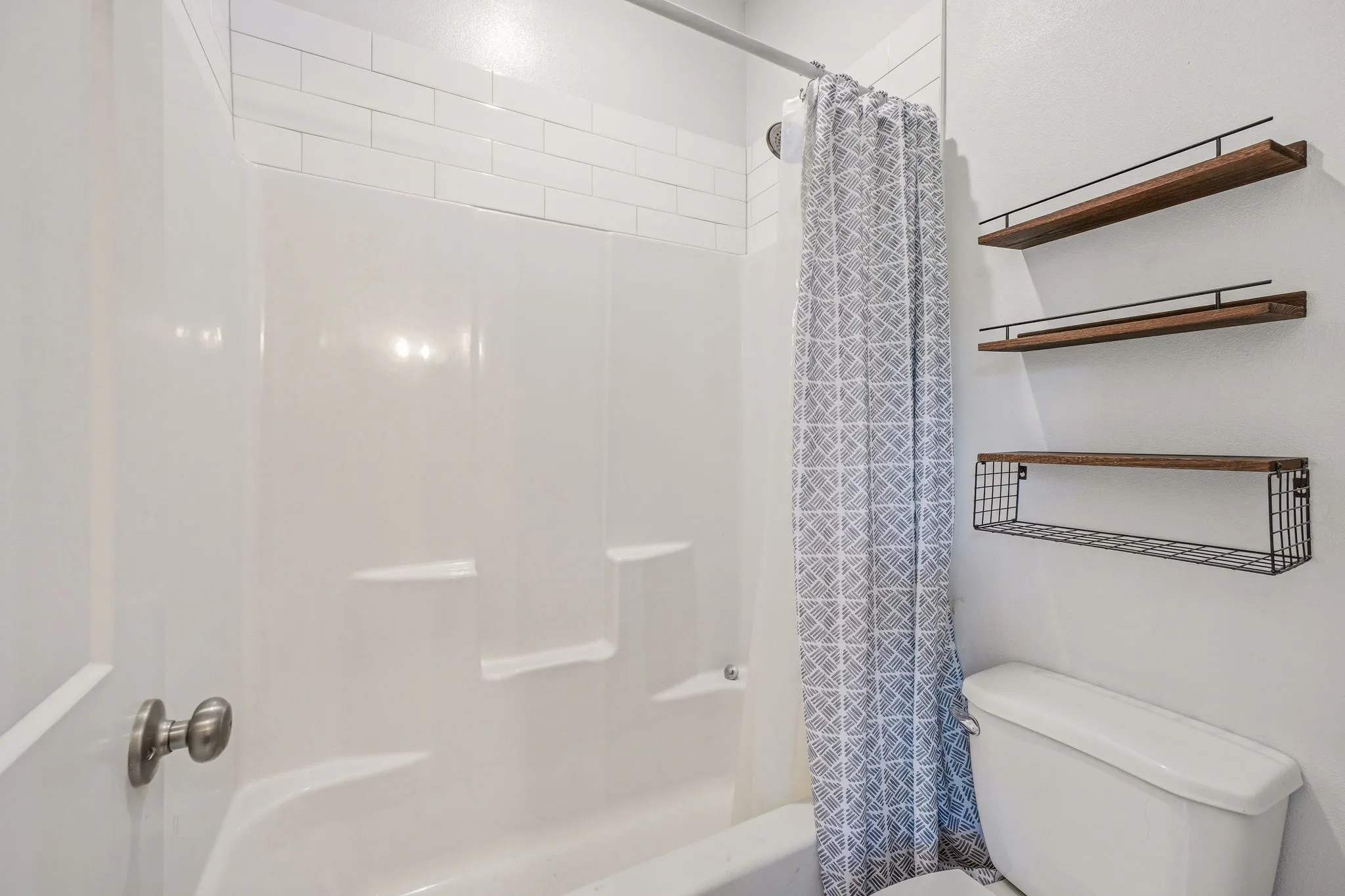 White subway tile accents a bright tub and shower combination