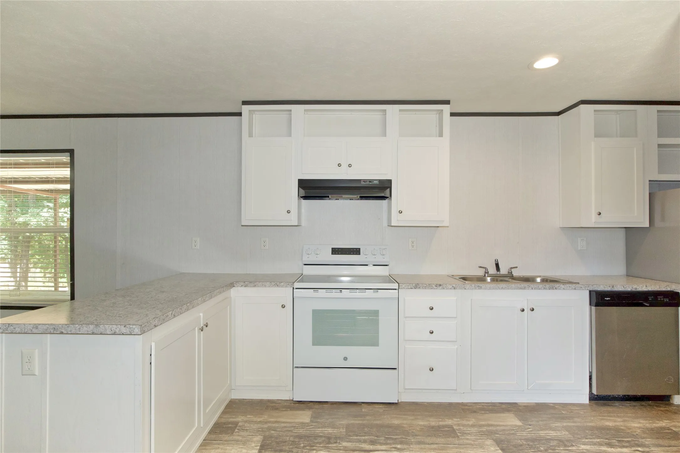 Kitchen featuring white cabinetry, white electric range, stainless steel dishwasher, double basin sink, and wood-finish flooring