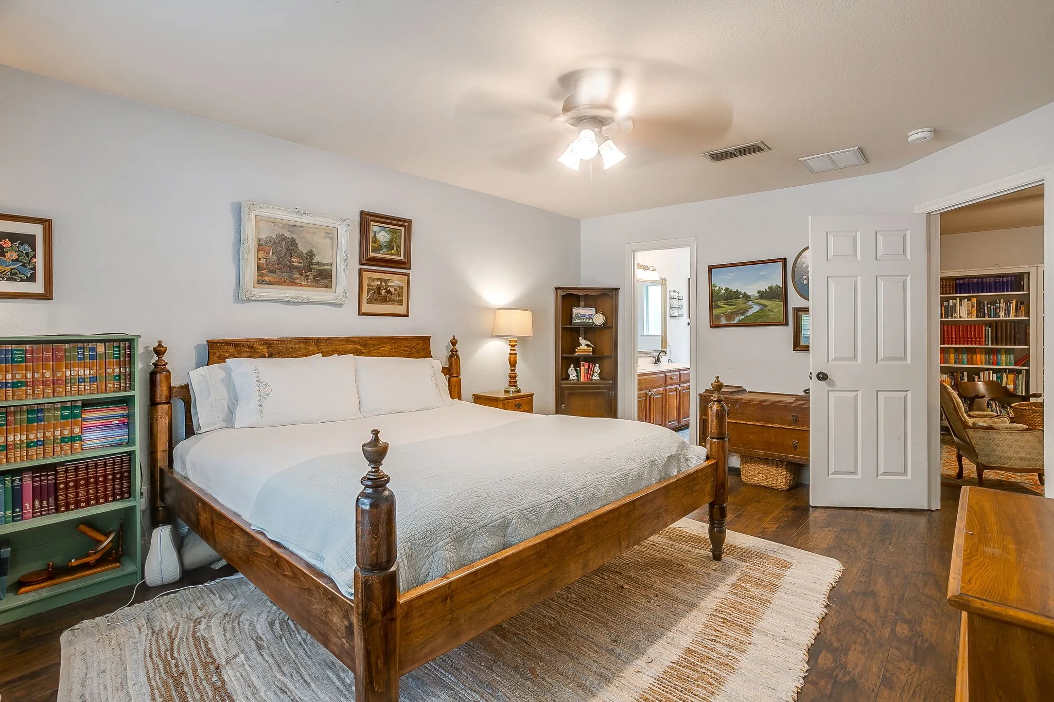 Spacious room featuring wood-finish flooring, a ceiling fan, and light-colored wall paint