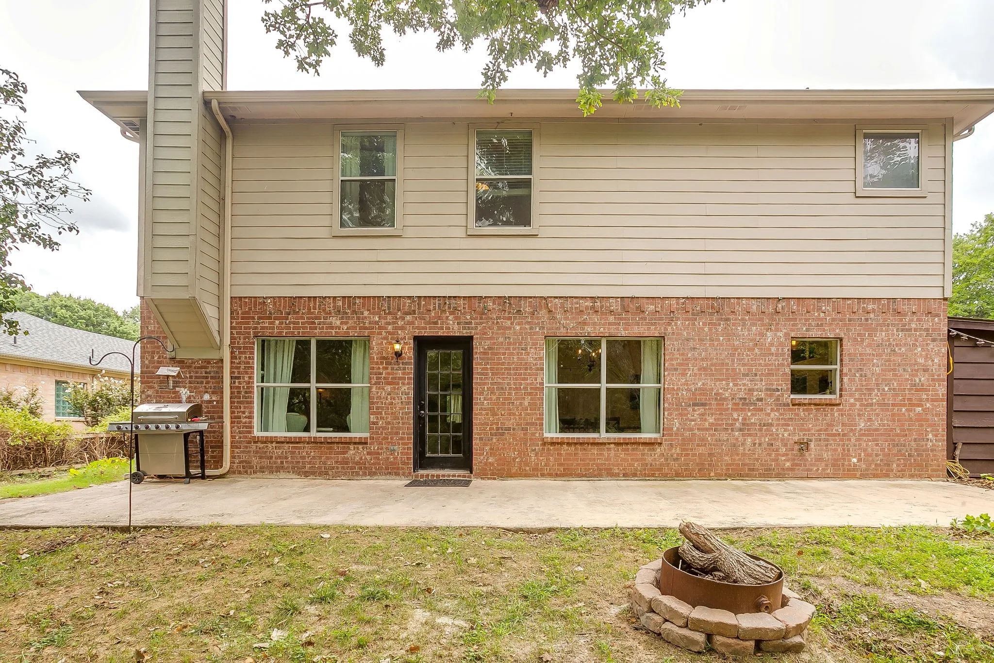 Two-story exterior featuring a brick first level and horizontal siding on the second level