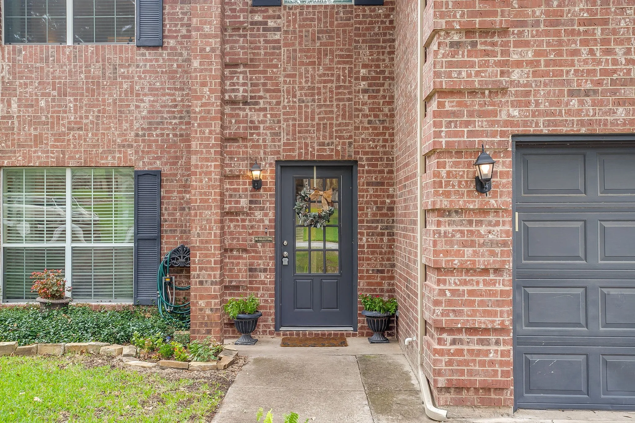 Brick facade with a dark gray front door featuring glass paneling