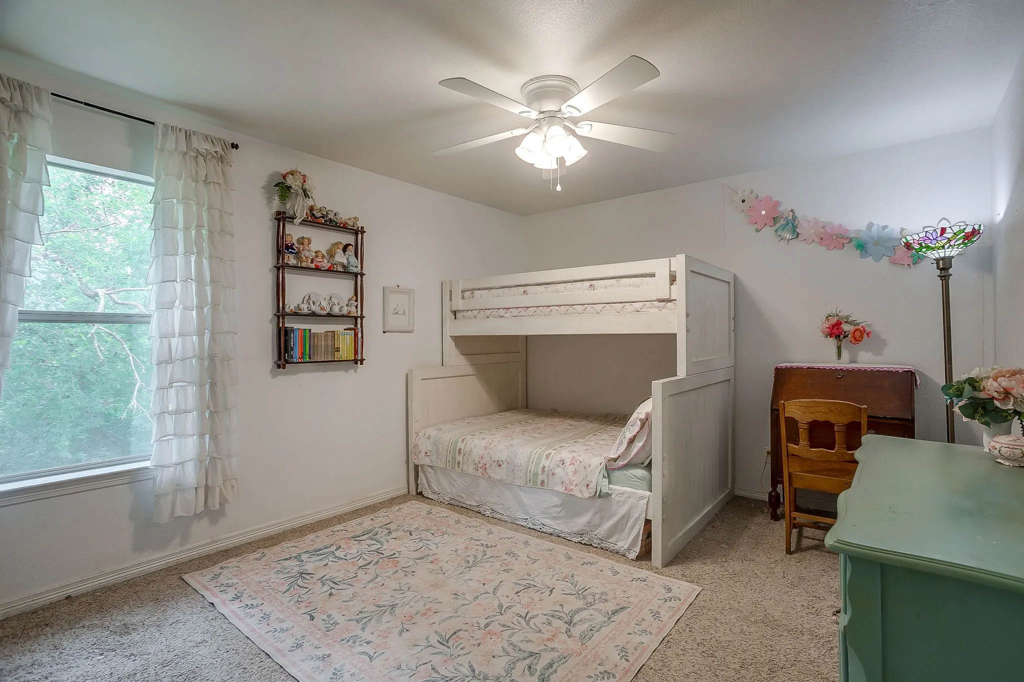 Room featuring a window with natural light, a ceiling fan with integrated lighting, and neutral wall paint