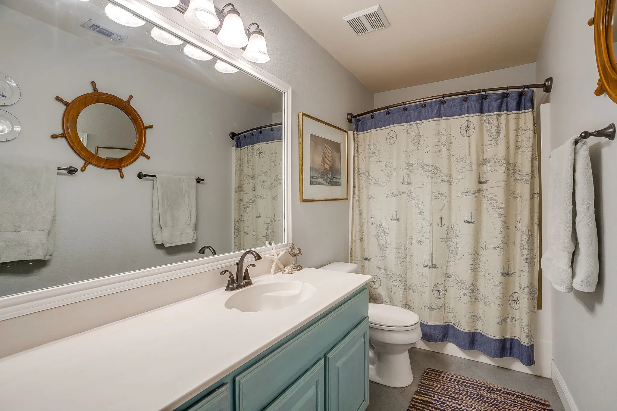 Bathroom featuring an extended vanity with an integrated sink, a dark bronze faucet, and a large wall-mounted mirror